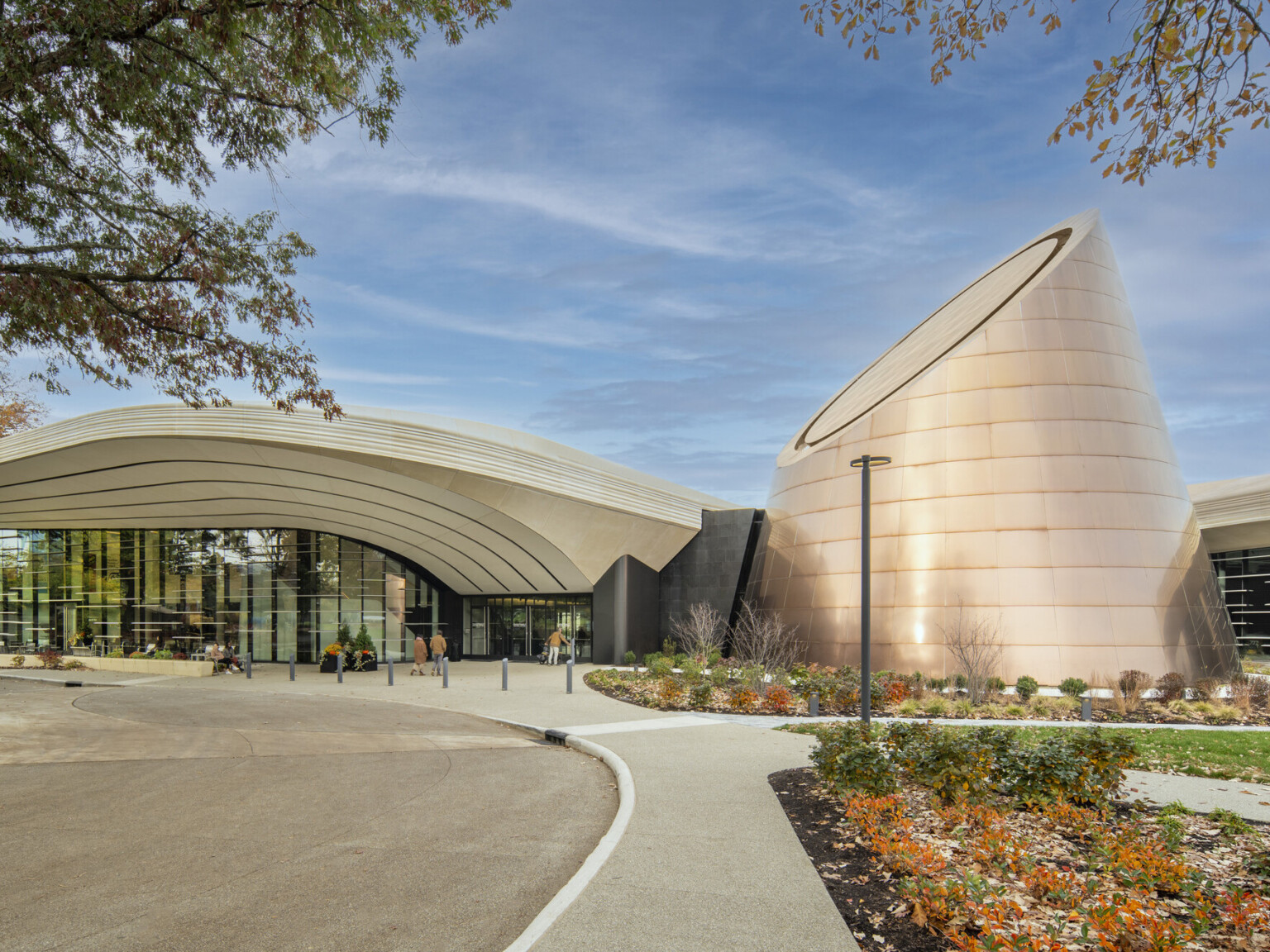 Modern building with a cone shaped tower surrounded by landscaping