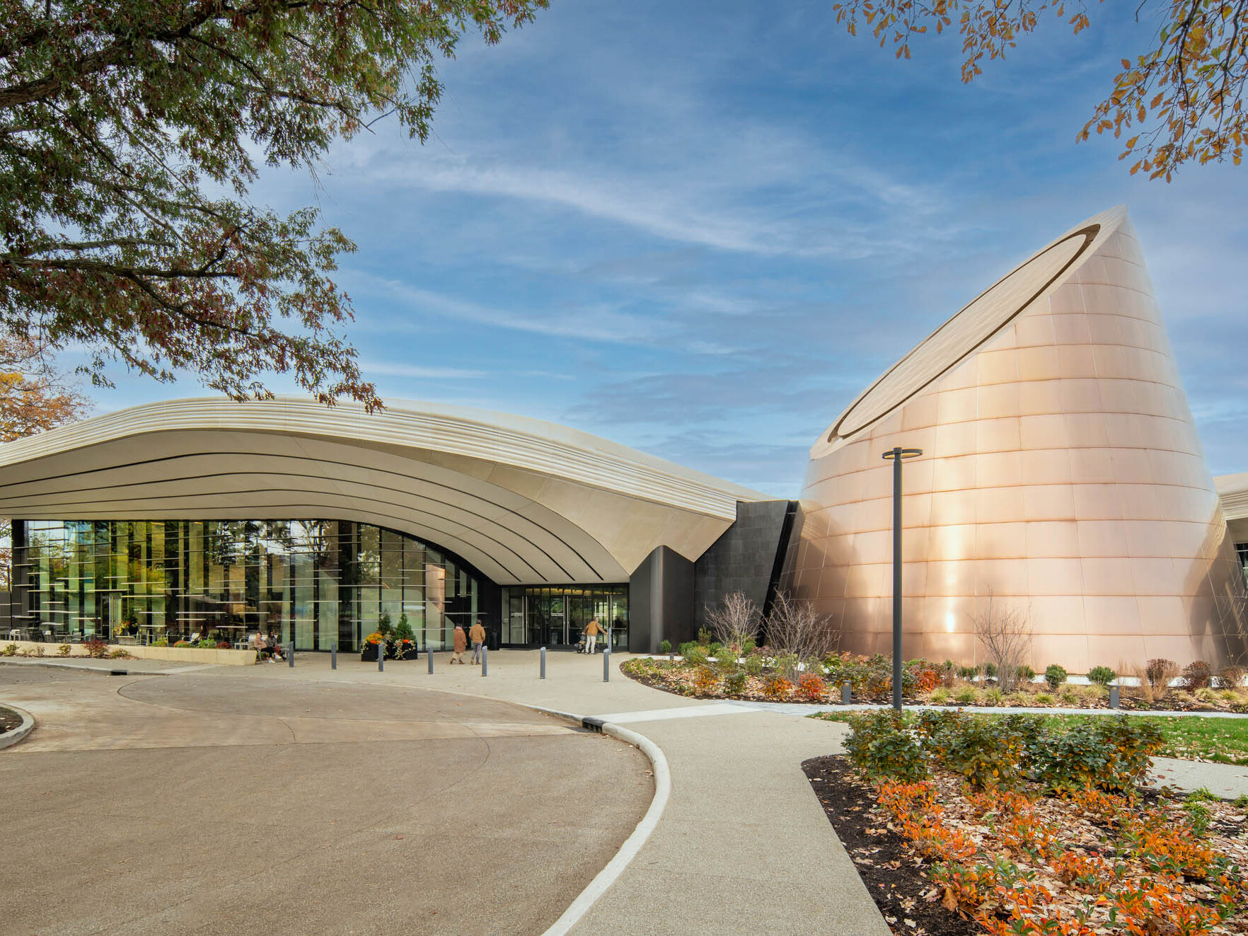 Modern building with a cone shaped tower surrounded by landscaping