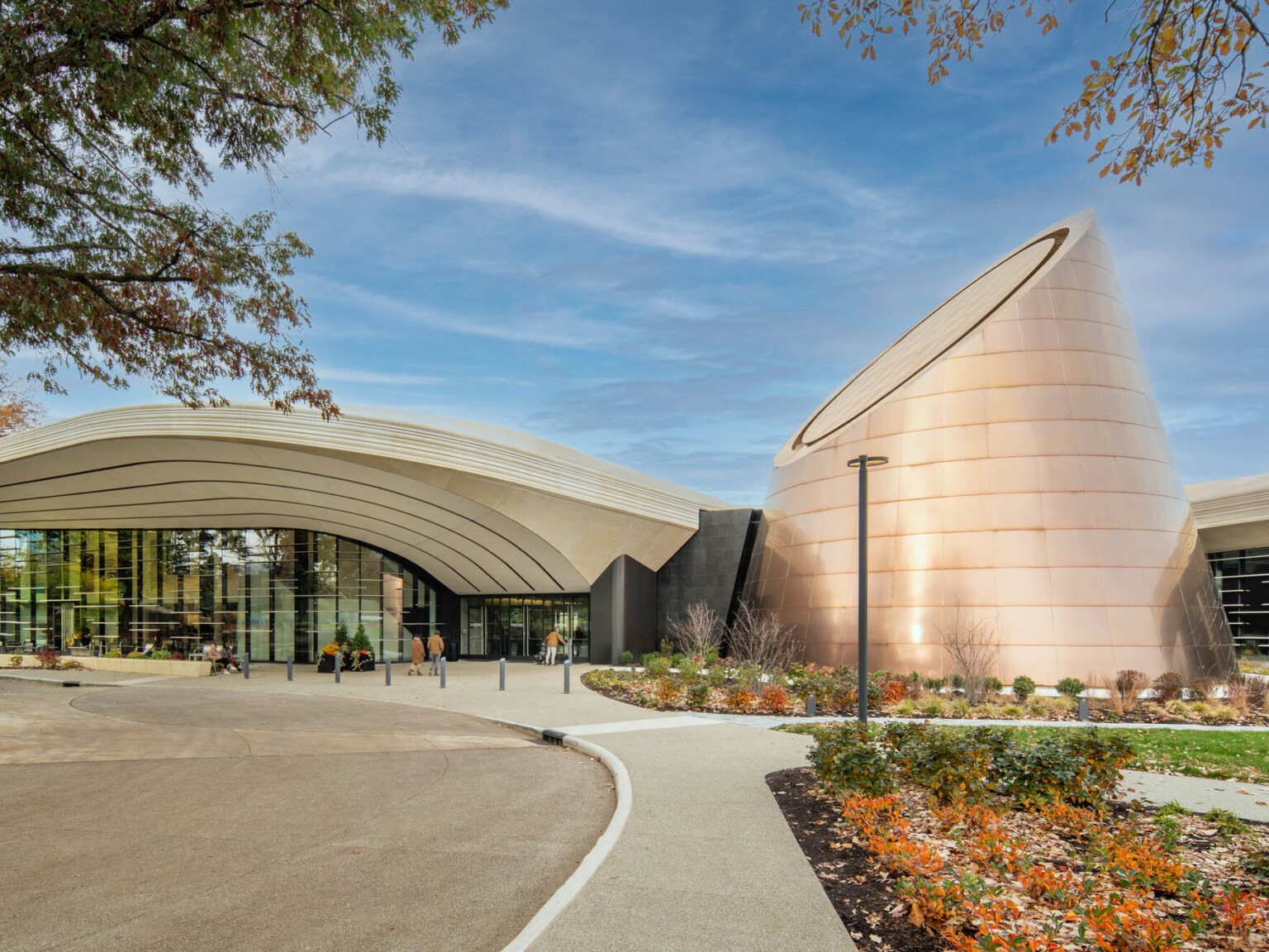 Modern building with a cone shaped tower surrounded by landscaping
