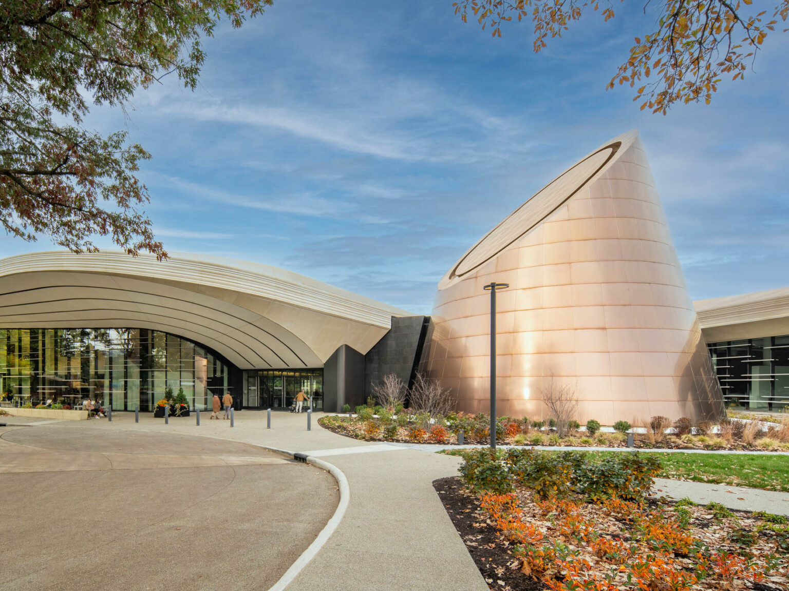 Modern building with a cone shaped tower surrounded by landscaping