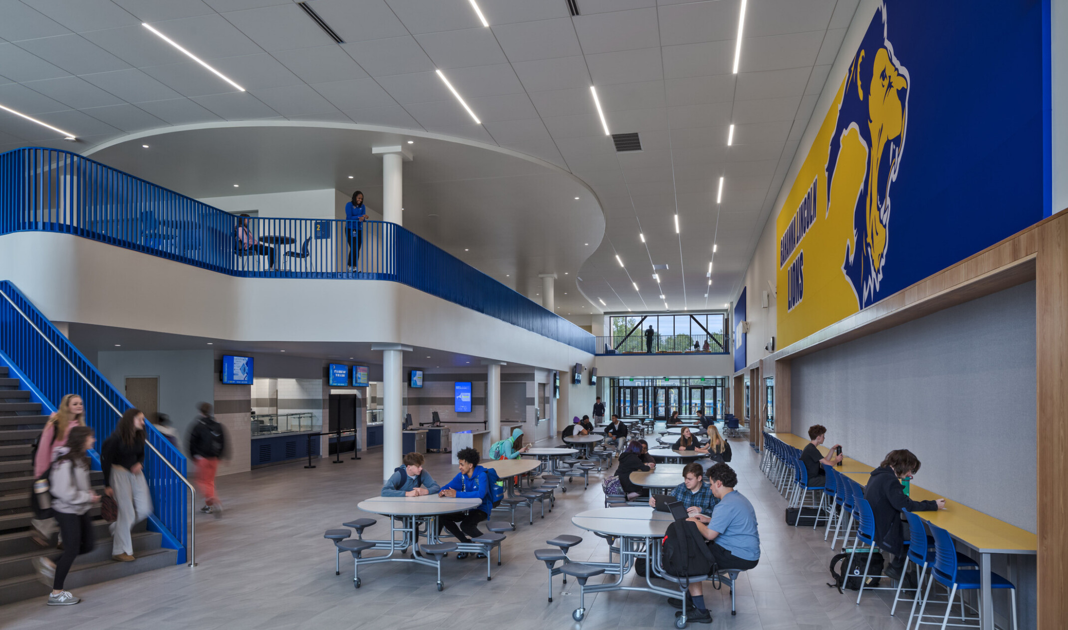 modern double height high school cafeteria with blue and yellow wall designs