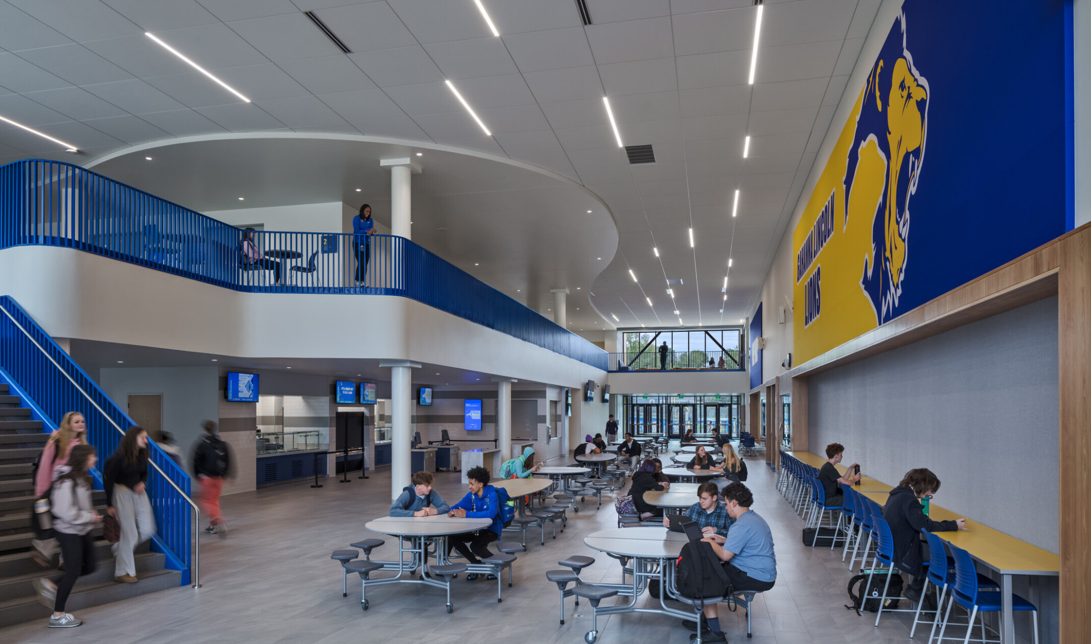 modern double height high school cafeteria with blue and yellow wall designs