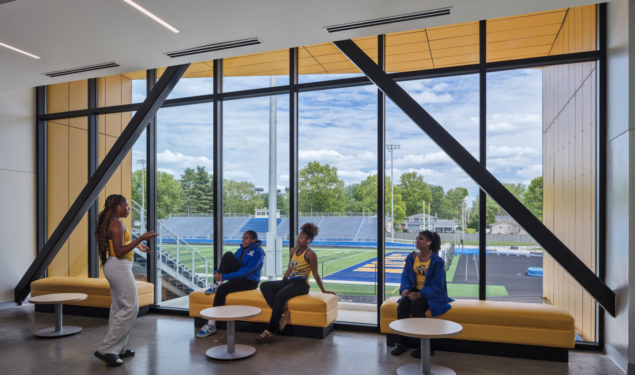 gathering area, public use in lincoln high school; varied seating with small tables and chairs; visible, open windows to outdoors