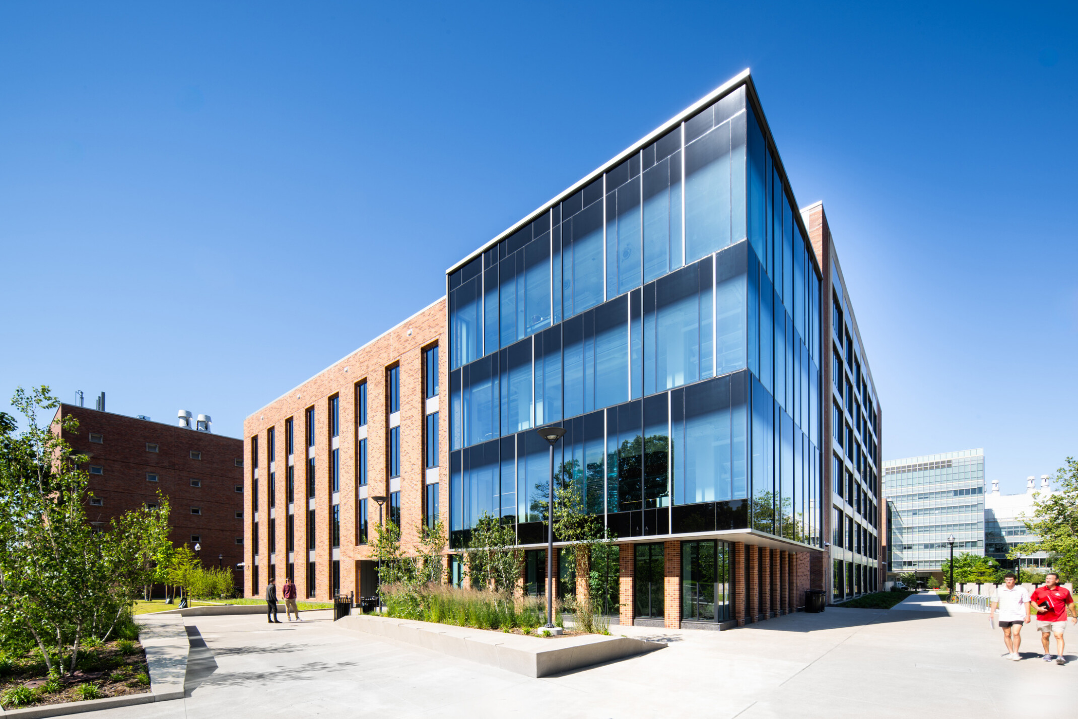 exterior of a modern building with a multi-facade treatment; entrance with floor to ceiling windows