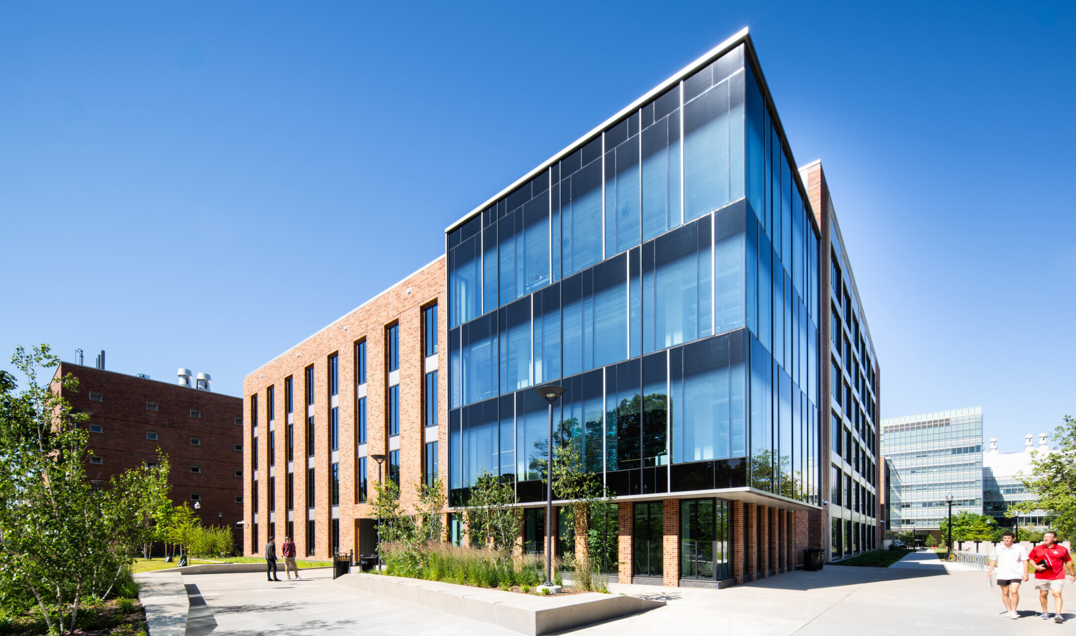 exterior of a modern building with a multi-facade treatment; entrance with floor to ceiling windows