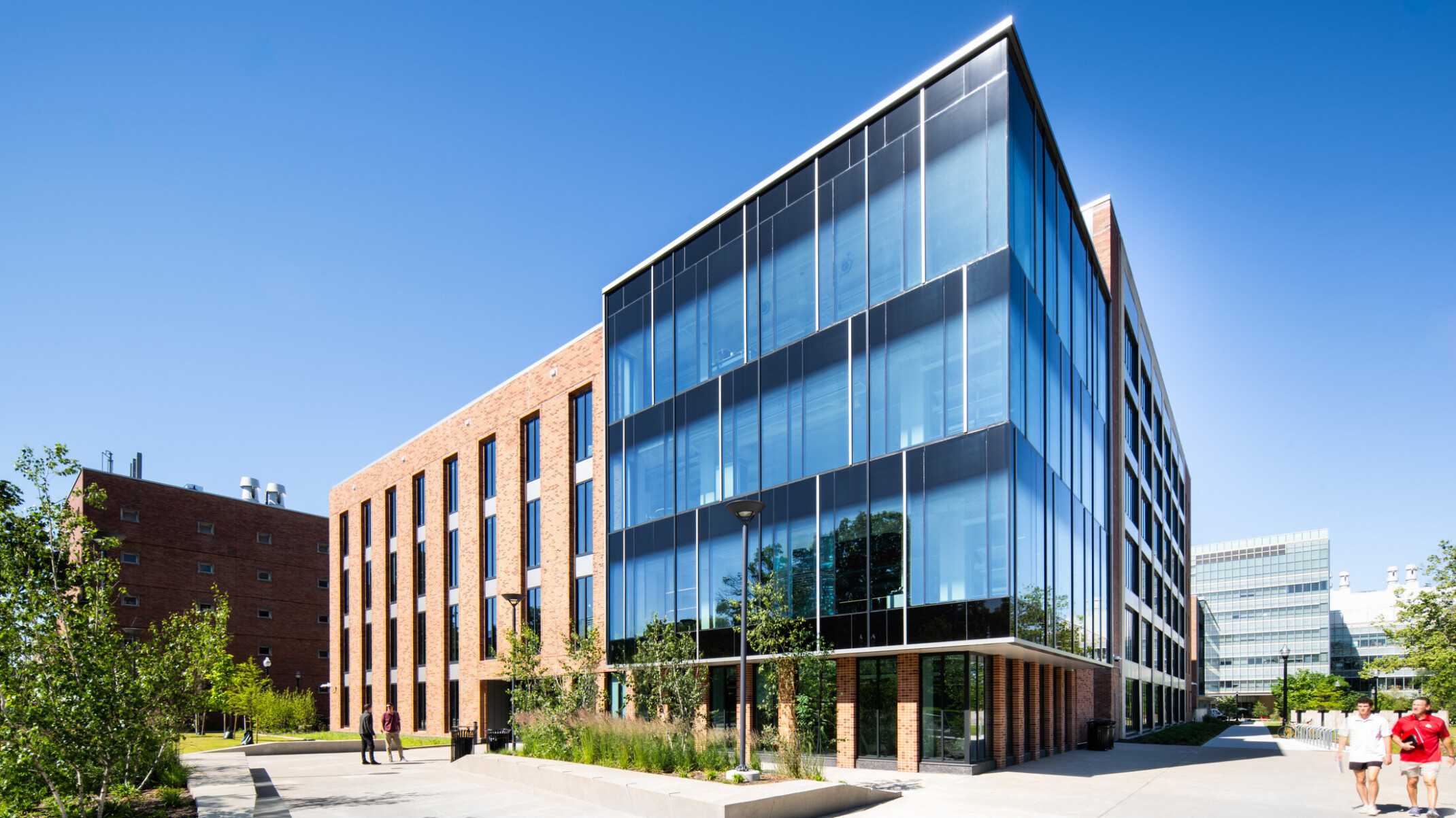 exterior of a modern building with a multi-facade treatment; entrance with floor to ceiling windows