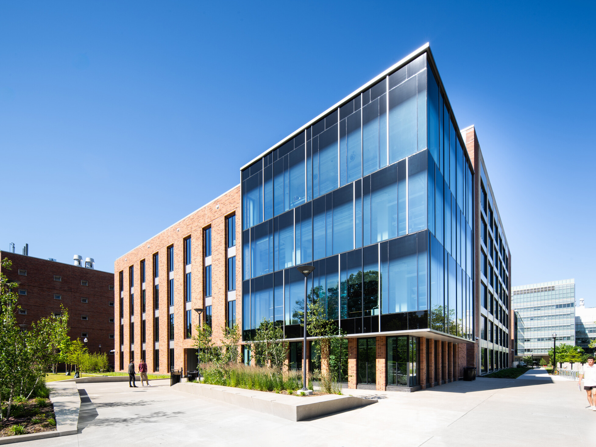 exterior of a modern building with a multi-facade treatment; entrance with floor to ceiling windows