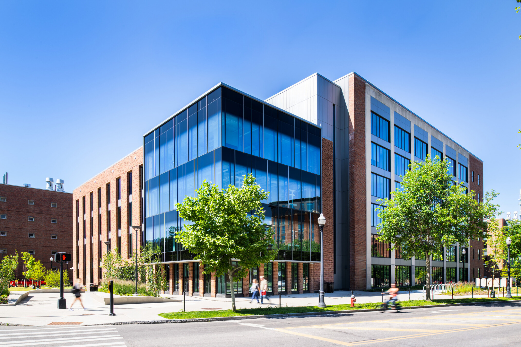 exterior of a modern building with a multi-facade treatment; entrance with floor to ceiling windows