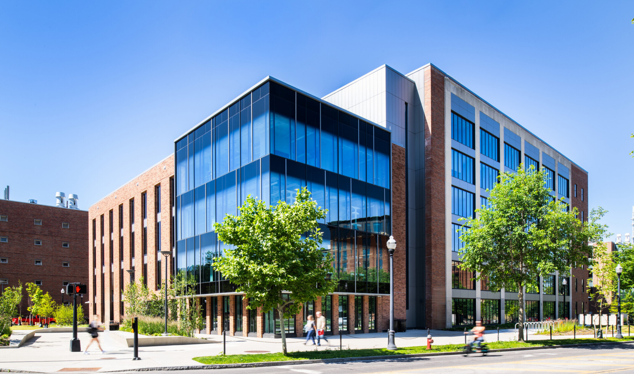 exterior of a modern building with a multi-facade treatment; entrance with floor to ceiling windows