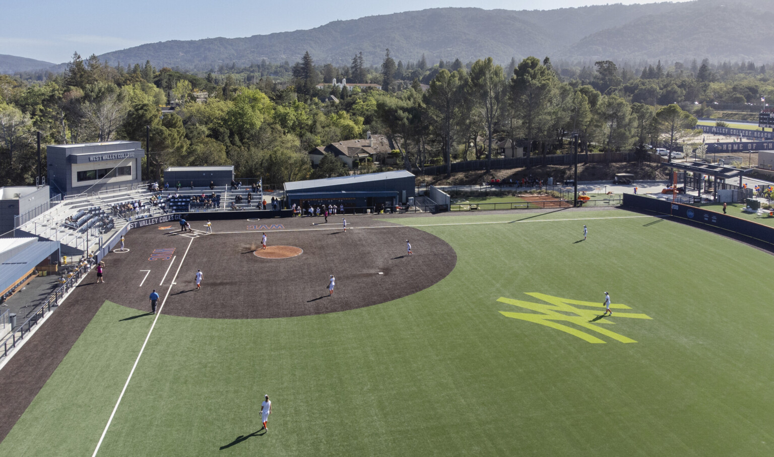 Aerial view from right field looking to home plate, bleachers and box seating labeled West Valley College. Santa Cruz Mountains behind