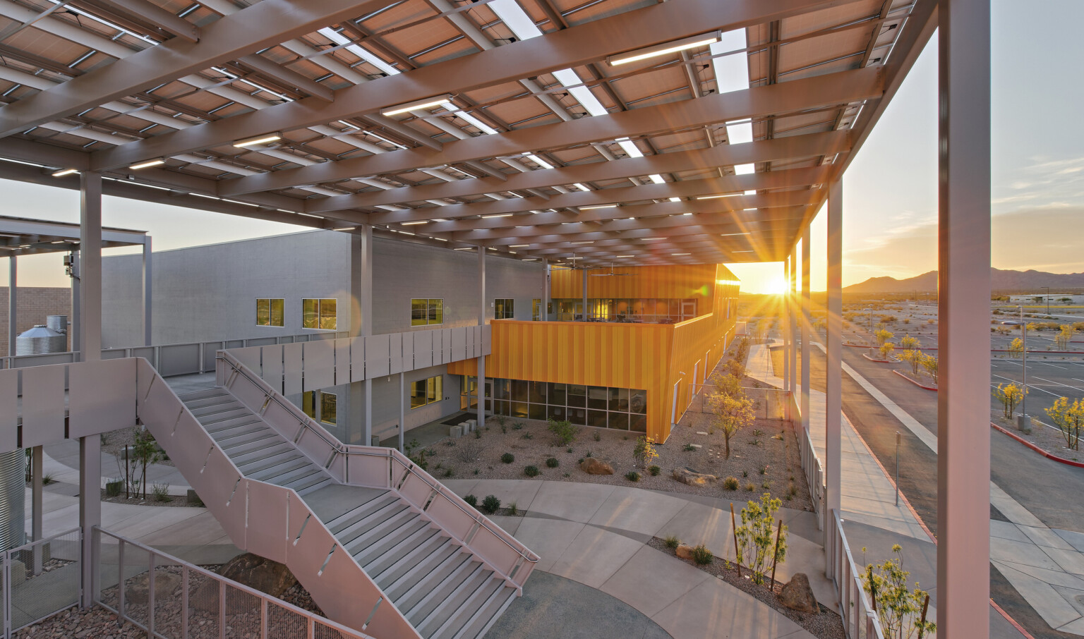 Western Maricopa Education Center (West-MEC) Southwest campus entrance. A 2 story grey and yellow building with solar canopy