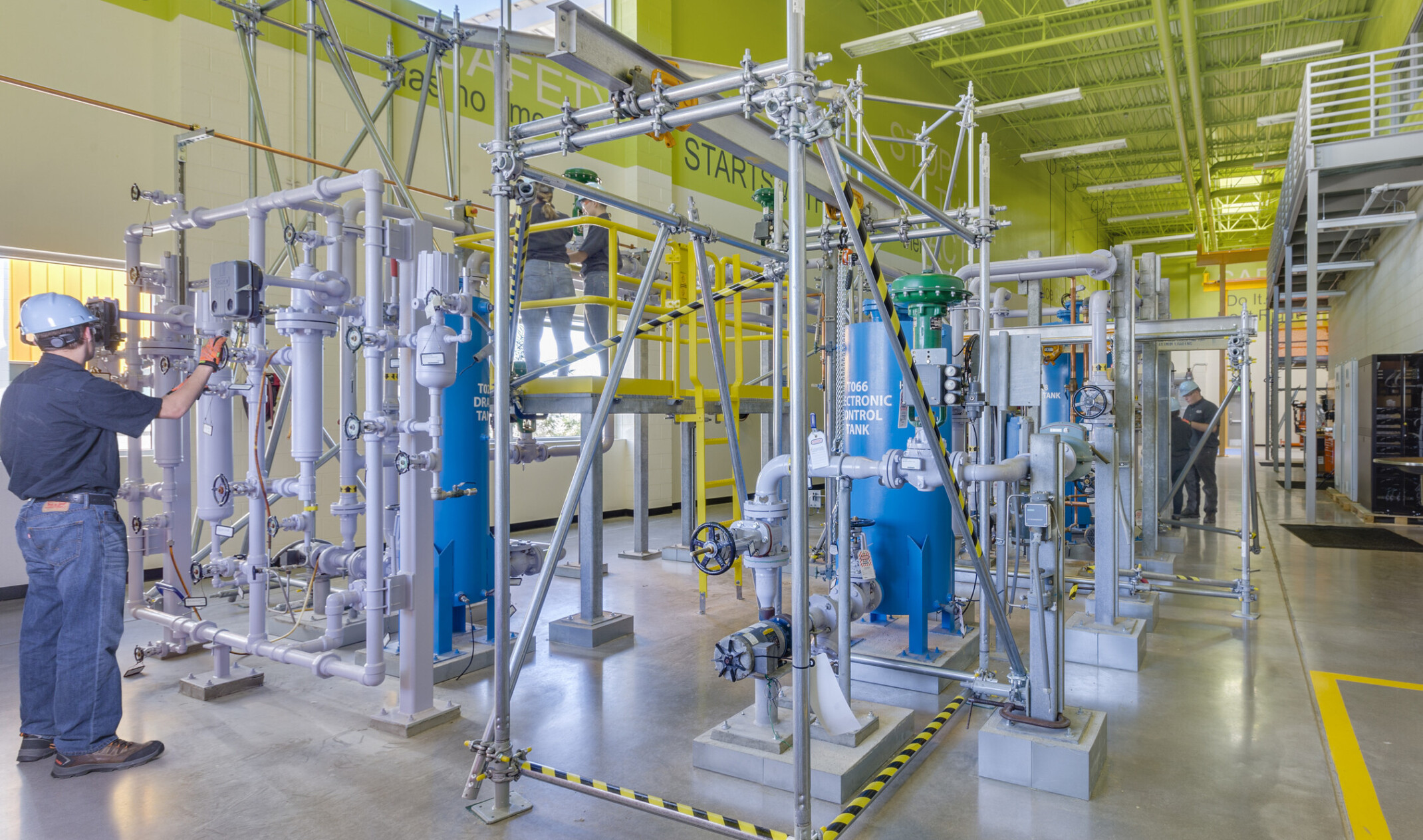 high bay work stations in a room with concrete floors and a lime green ceiling