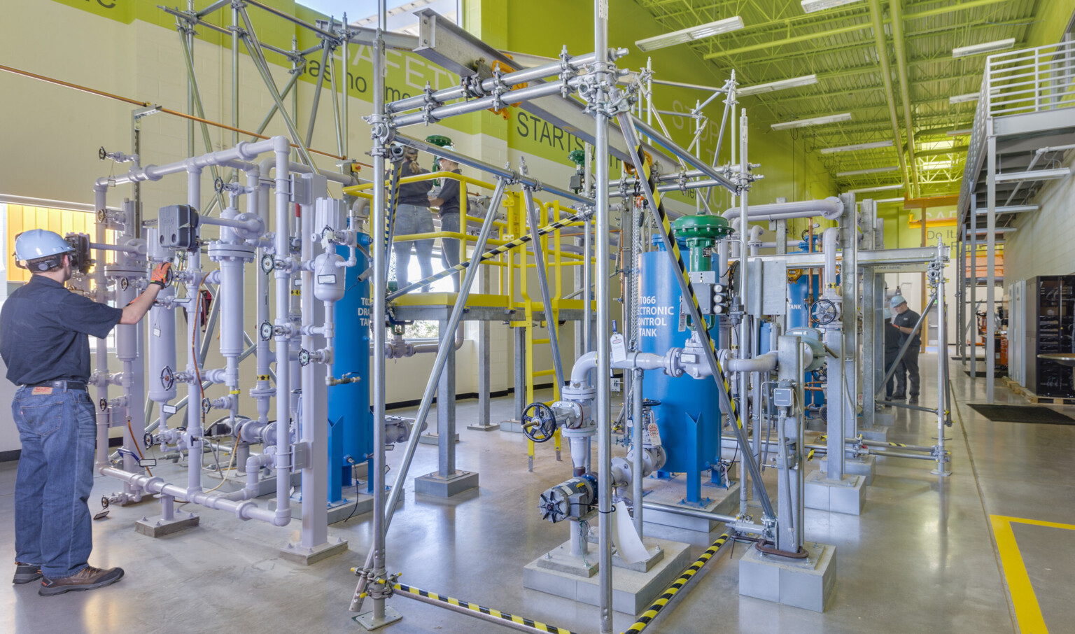 high bay work stations in a room with concrete floors and a lime green ceiling