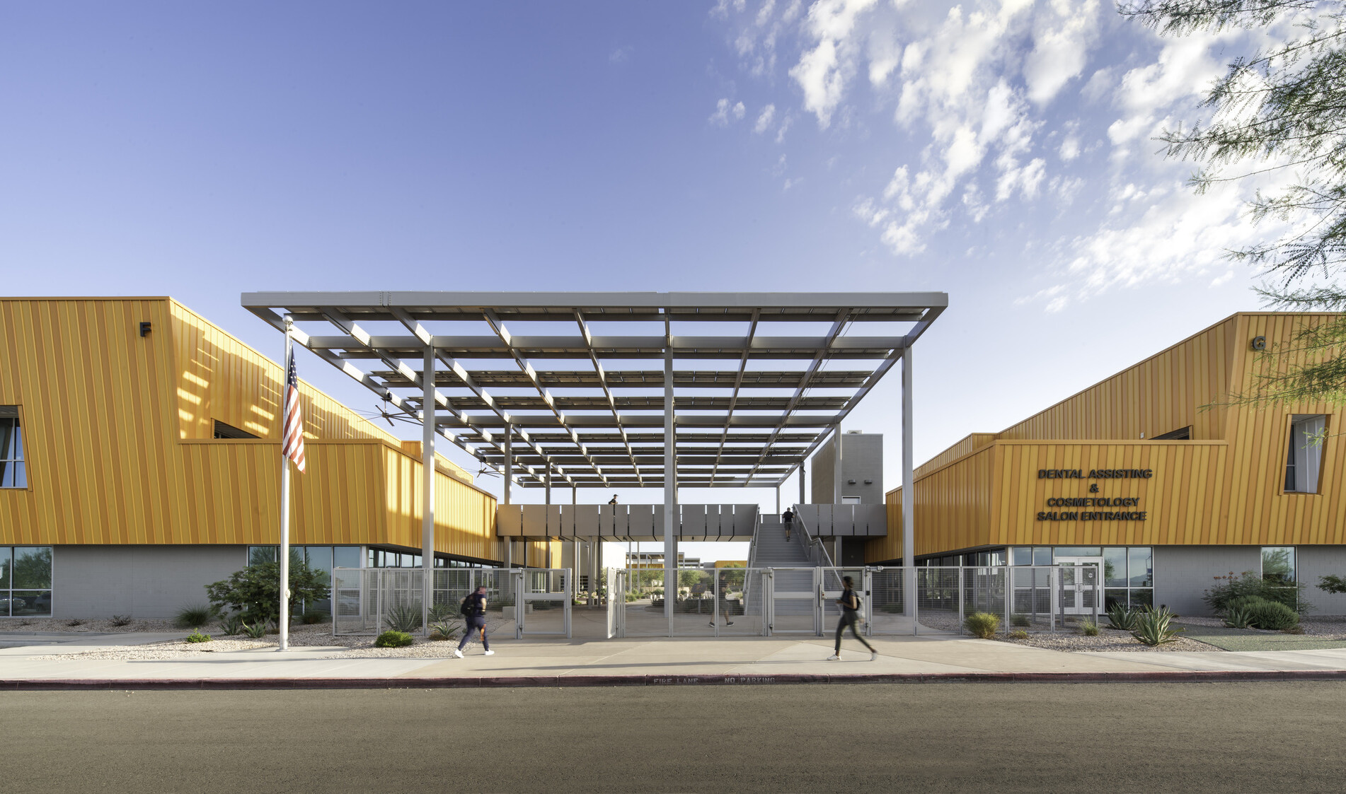front entrance of a school; symmetrical buildings flank a semi-covered courtyard;