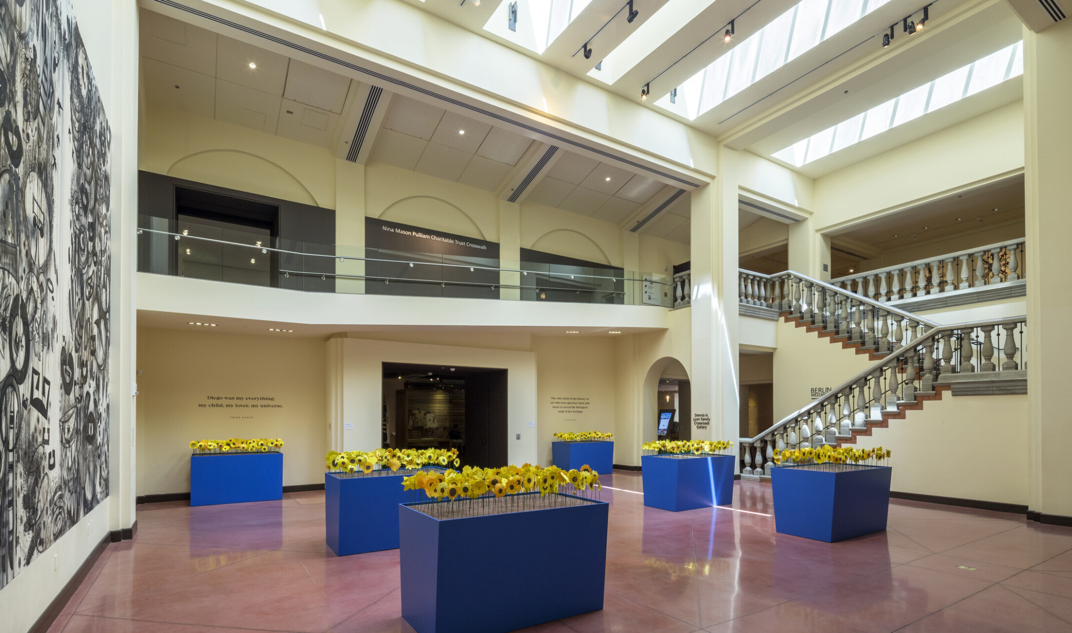 blue planters with yellow flowers in large open artrium with skylights at the heard museum