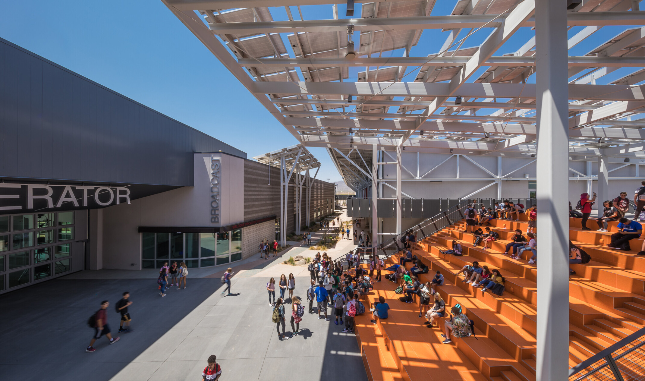 orange bleacher seating shaded by a solar panel canopy