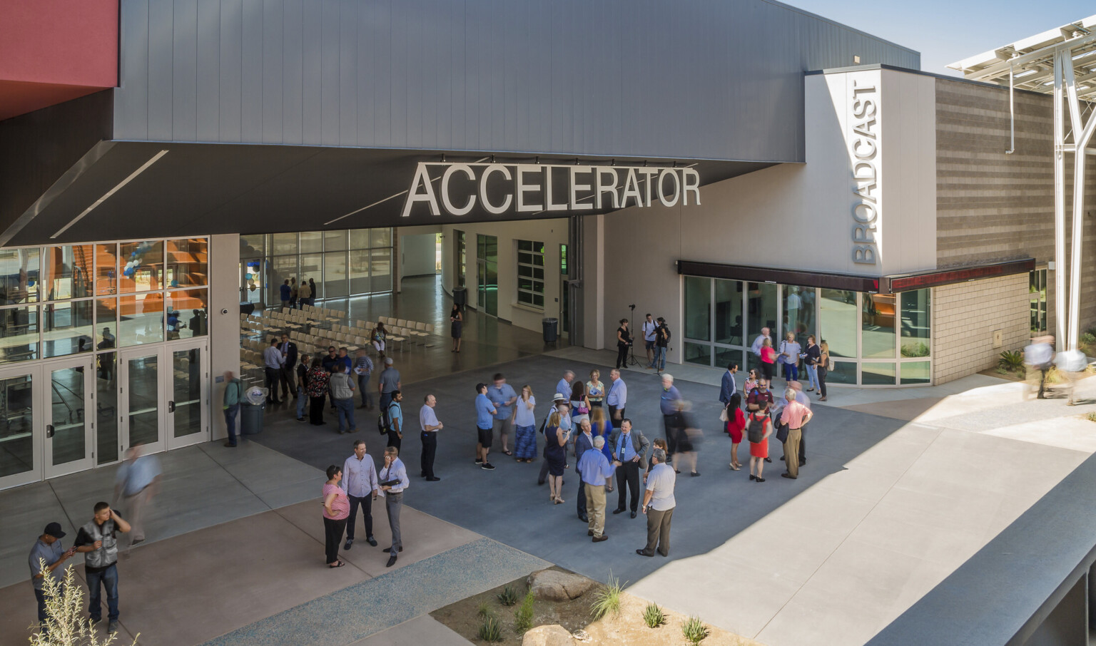 Section of building labeled Accelerator has an angled black roof above wall opening up a seating area to the patio