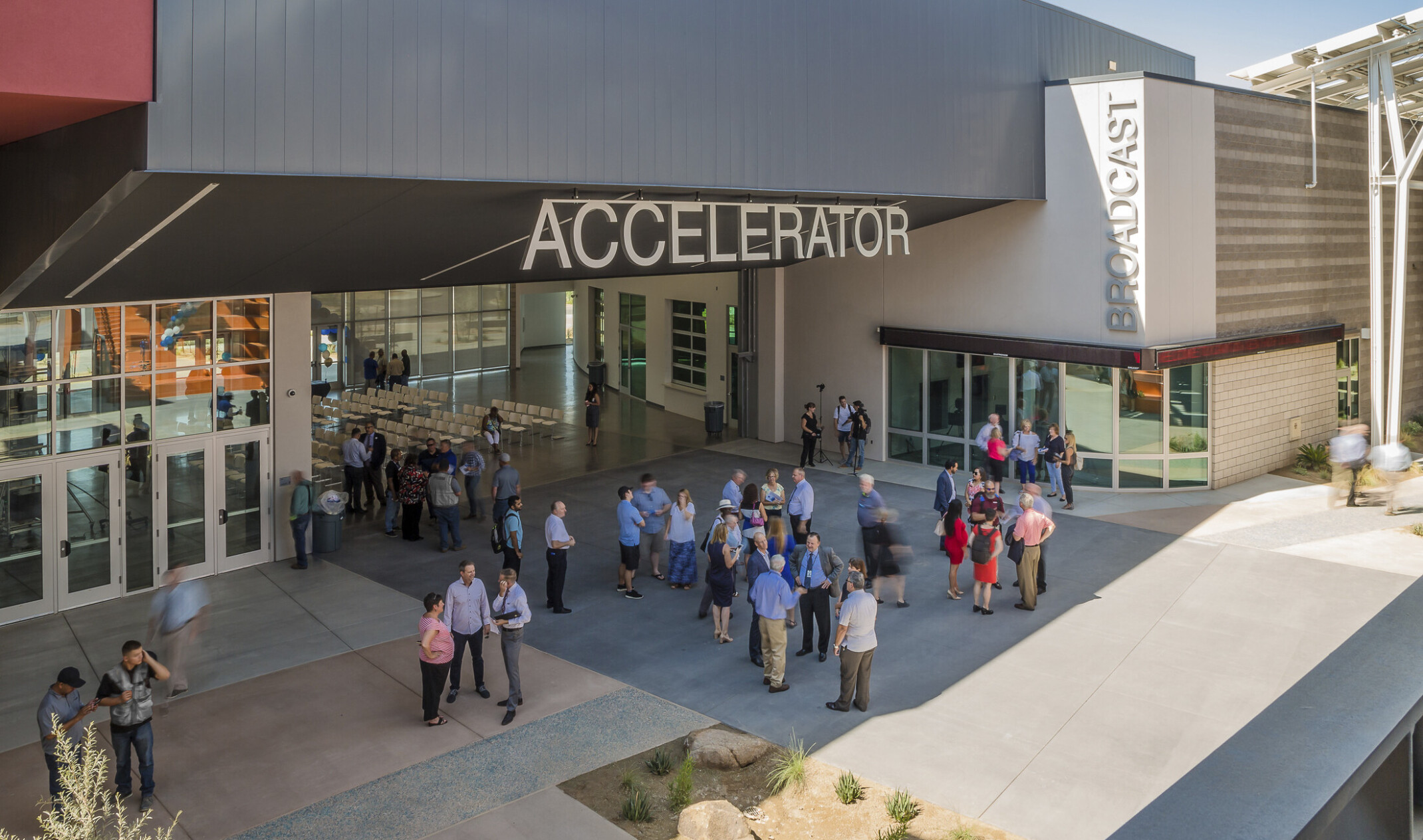 Section of building labeled Accelerator has an angled black roof above wall opening up a seating area to the patio