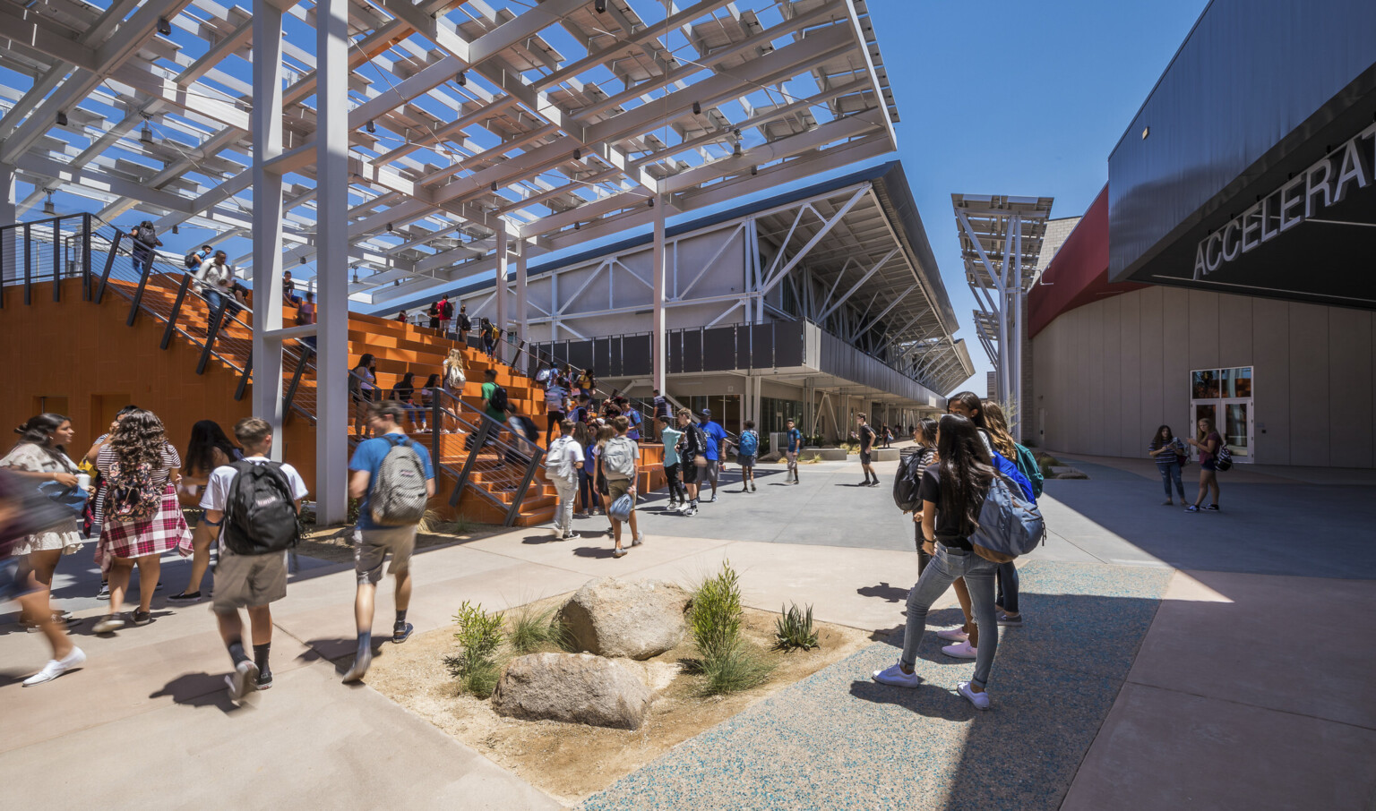 At the front of a walkway between buildings is a large orange partially covered staircase At the front of a walkway between buildings is a large orange partially covered staircase