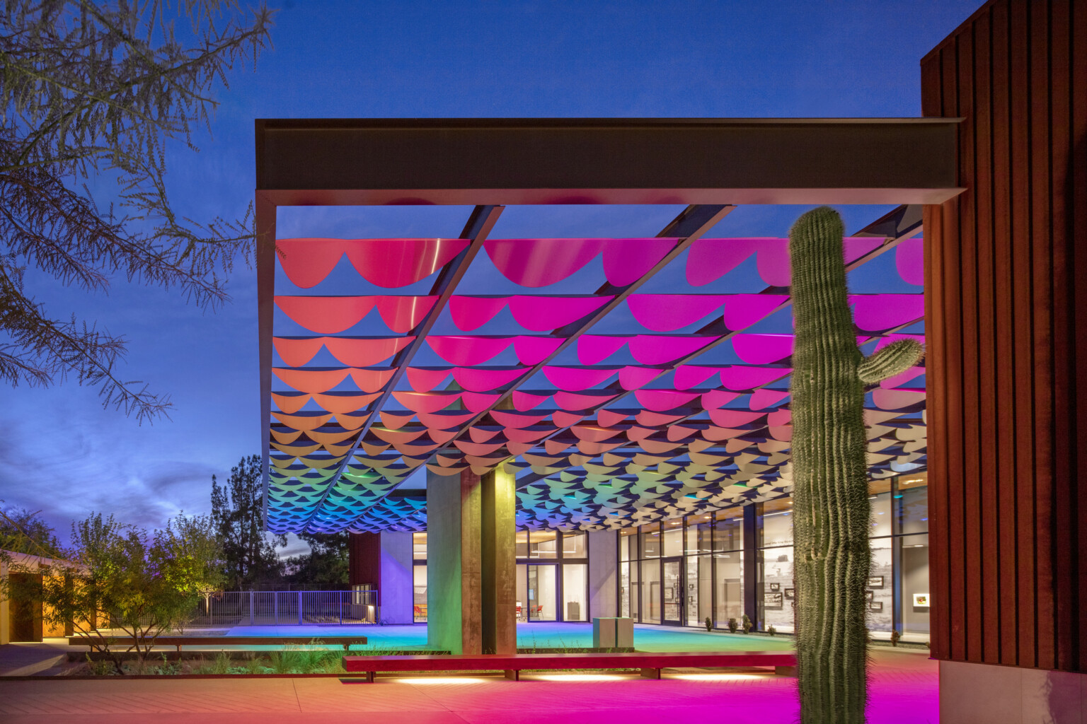 rainbow lit and scalloped awning against a evening sky
