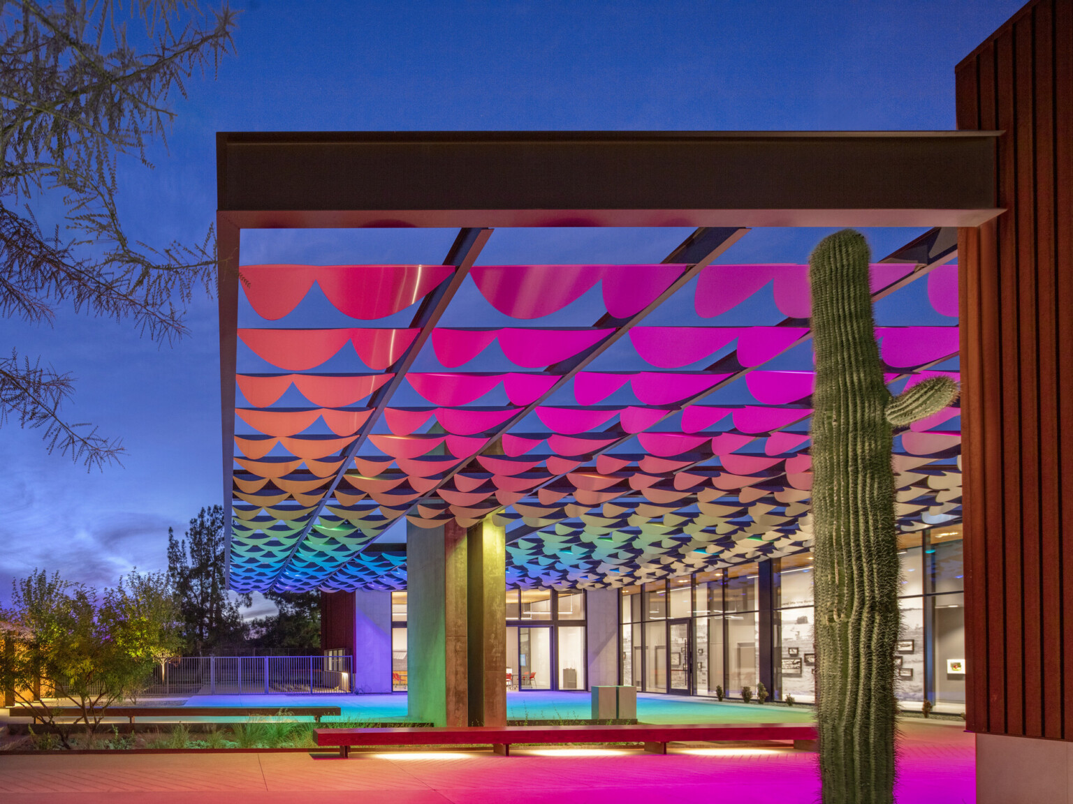 rainbow lit and scalloped awning against a evening sky