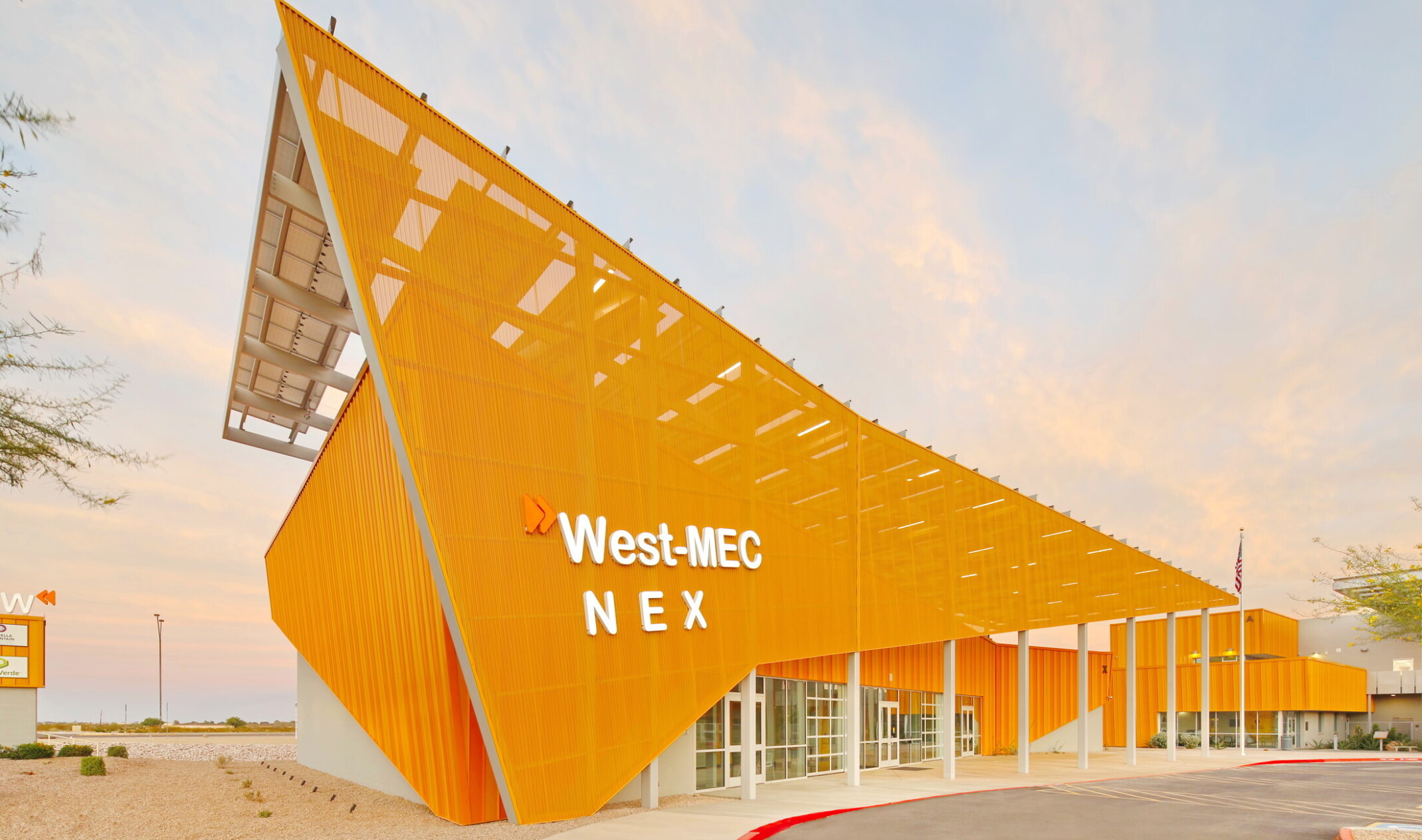West-MEC NEX building at the Southwest Campus, an angular yellow building with sunscreen across the front with white sign