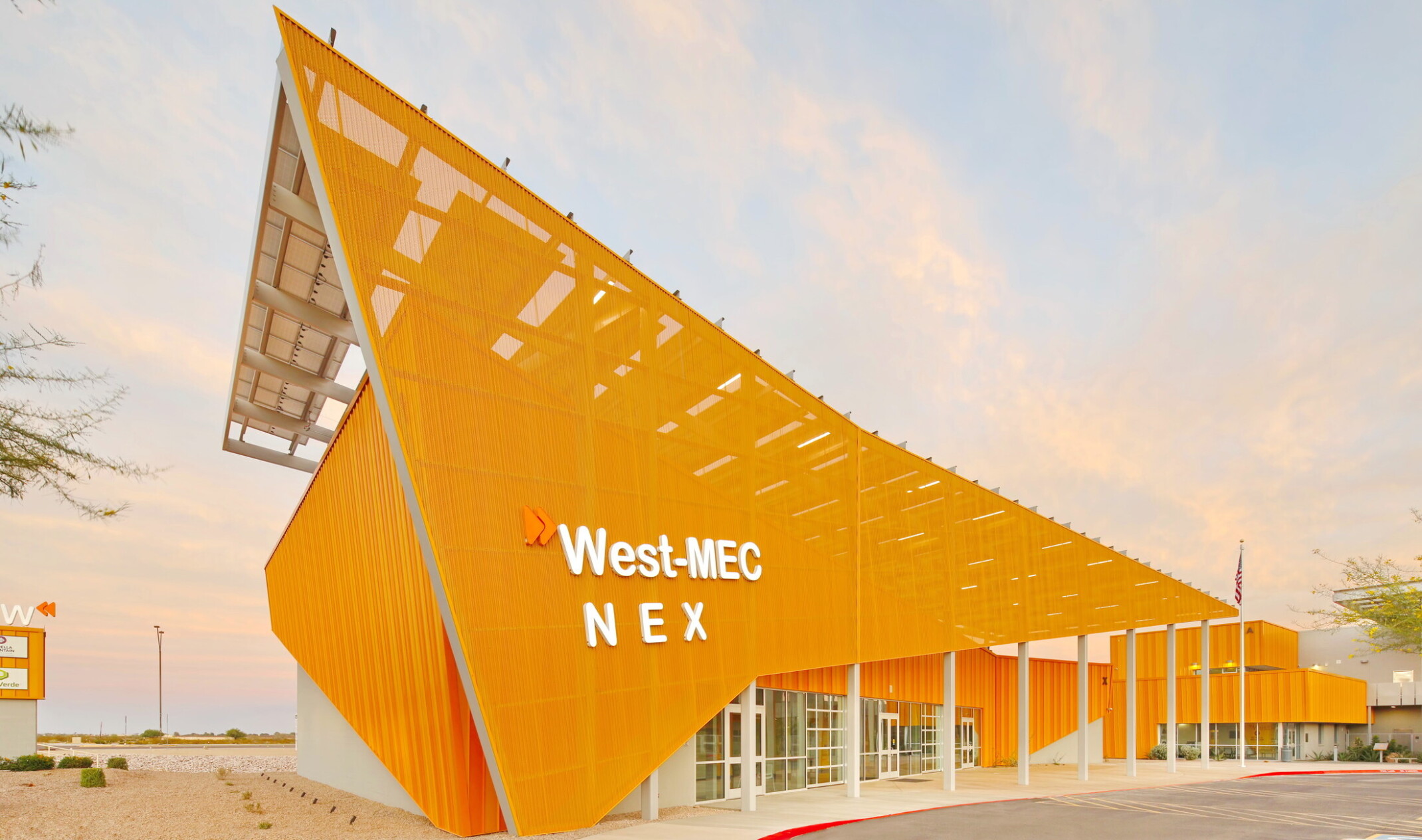 West-MEC NEX building at the Southwest Campus, an angular yellow building with sunscreen across the front with white sign