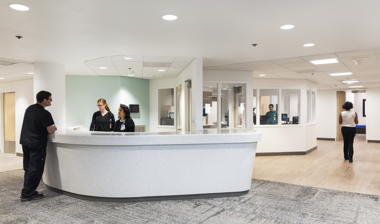 Valleywise Behavioral Health Center reception area with grey stone desk in front of hallway with irregularly shaped offices Valleywise Behavioral Health Center reception area with grey stone desk in front of hallway with irregularly shaped offices
