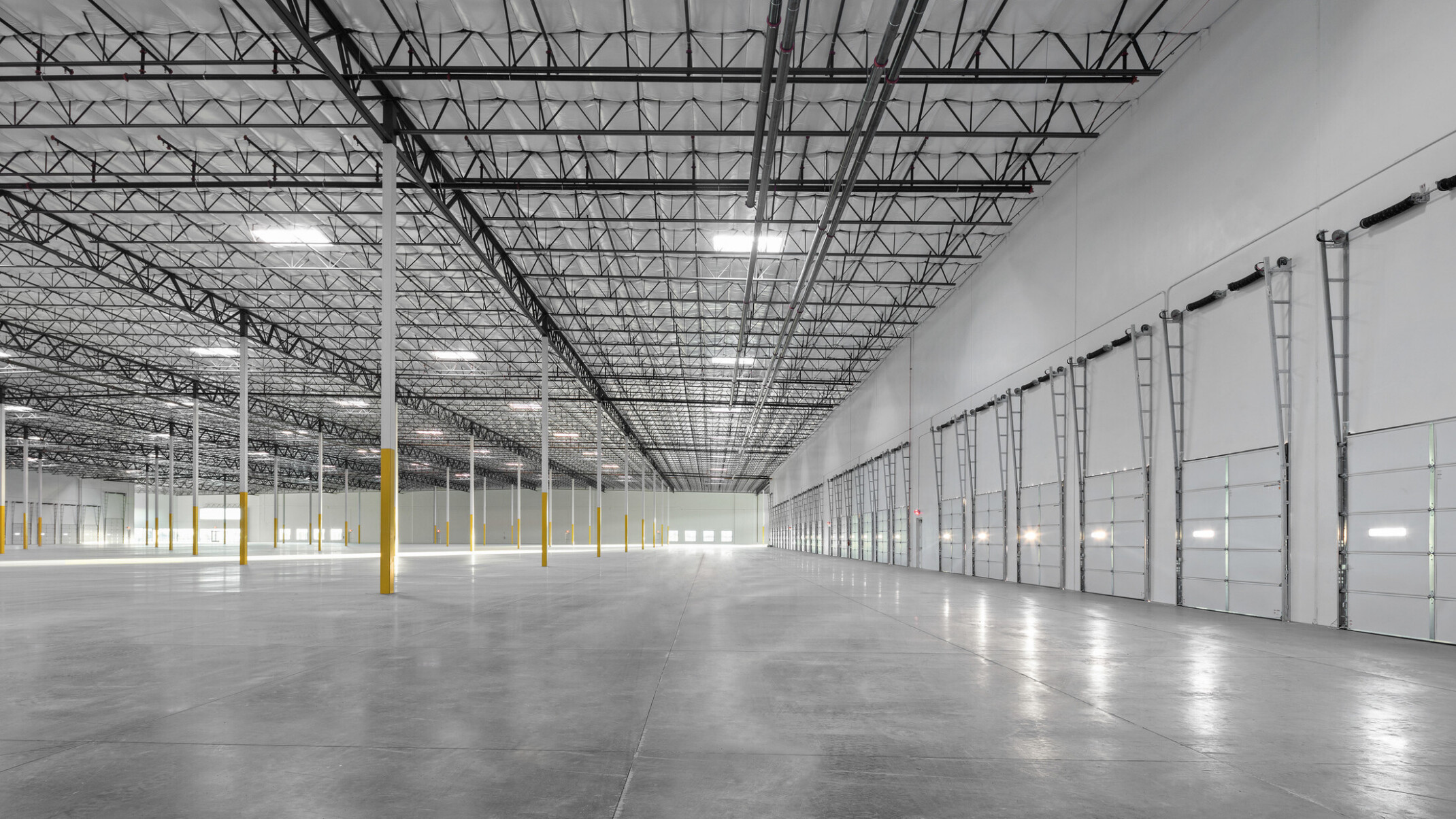Avondale Commerce Park speculative office area; double-height window system at entry flooding interior with natural light; soaring ceiling height accommodating future two-story office build-out or single-story with generous ceiling height; open unfinished interior ready for tenant improvement