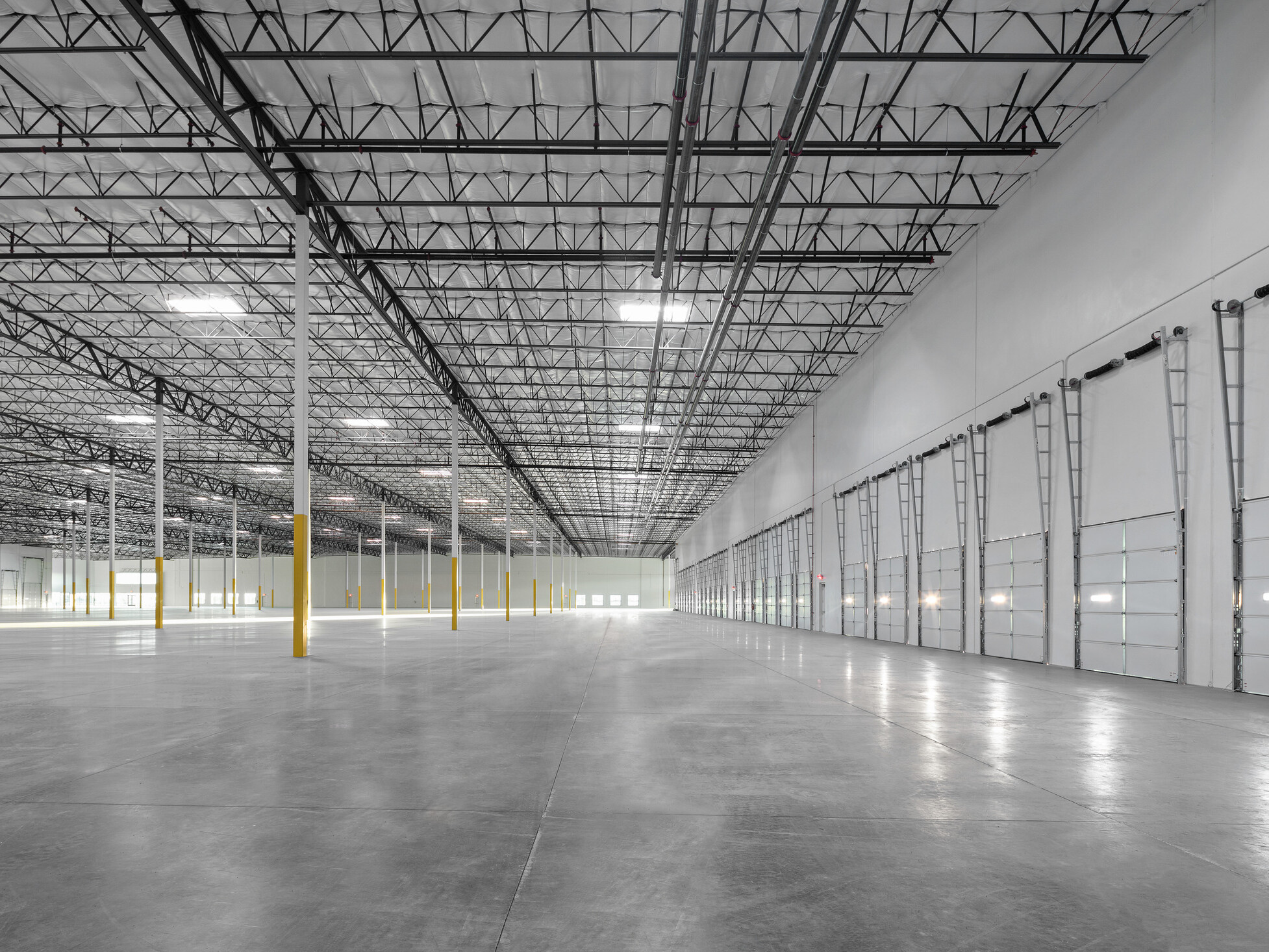 Avondale Commerce Park speculative office area; double-height window system at entry flooding interior with natural light; soaring ceiling height accommodating future two-story office build-out or single-story with generous ceiling height; open unfinished interior ready for tenant improvement