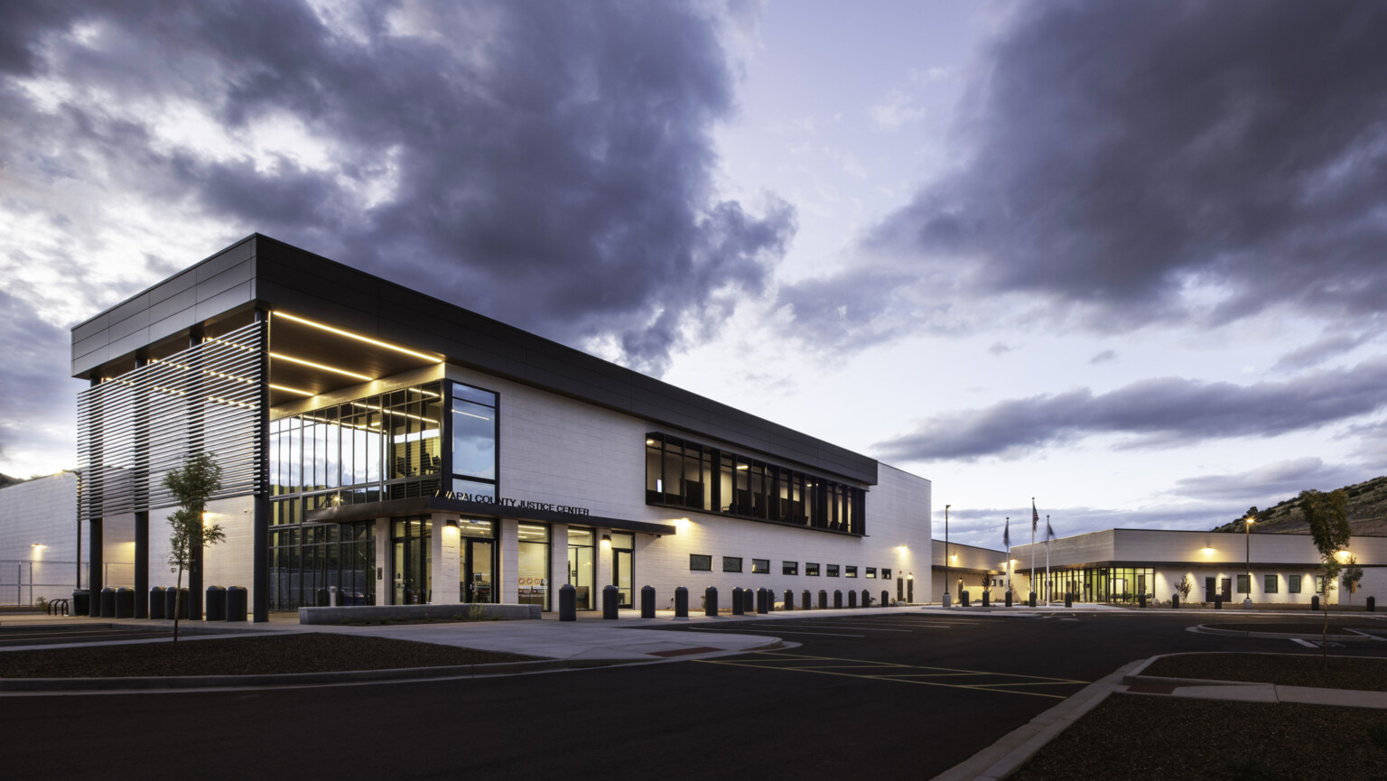 Exterior of Yavapai County Criminal Justice Center. Natural materials, floor to ceiling windows, building entrance