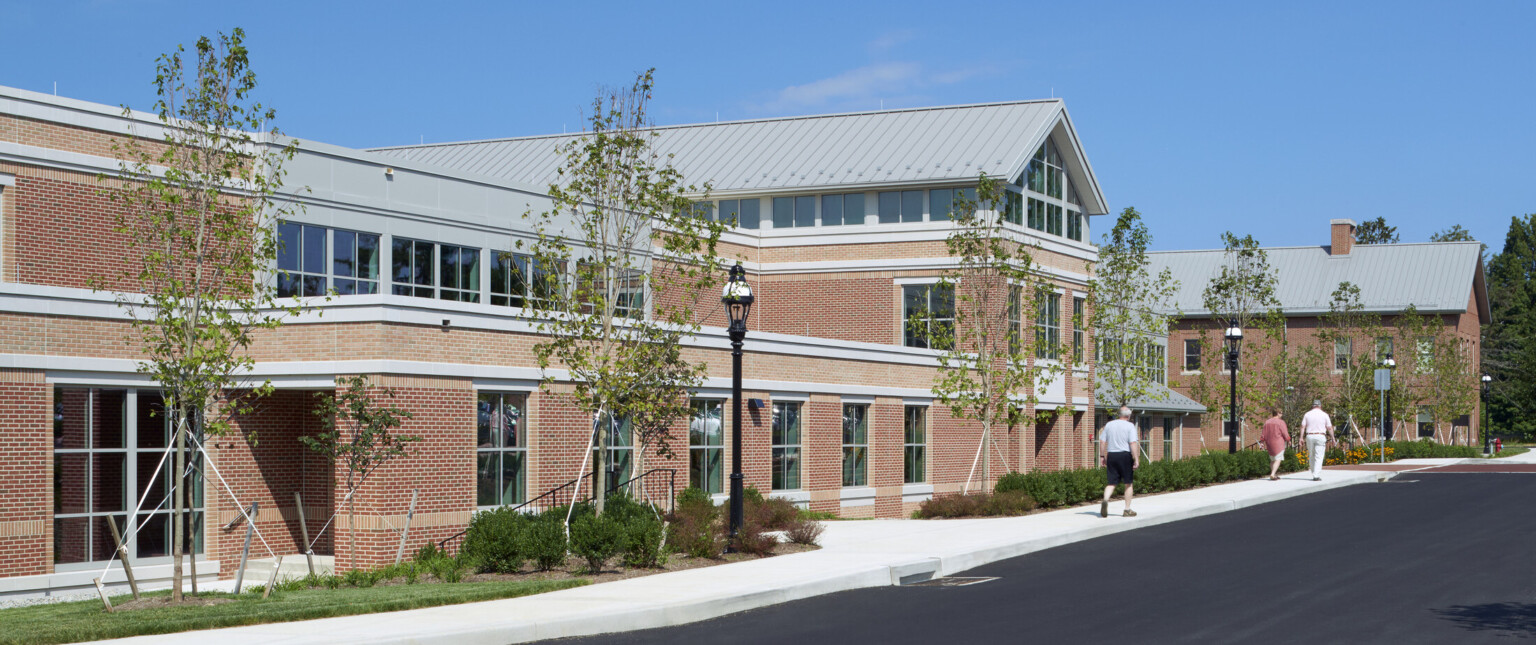 Exterior of the George School showing a red brick building with lush green landscaping