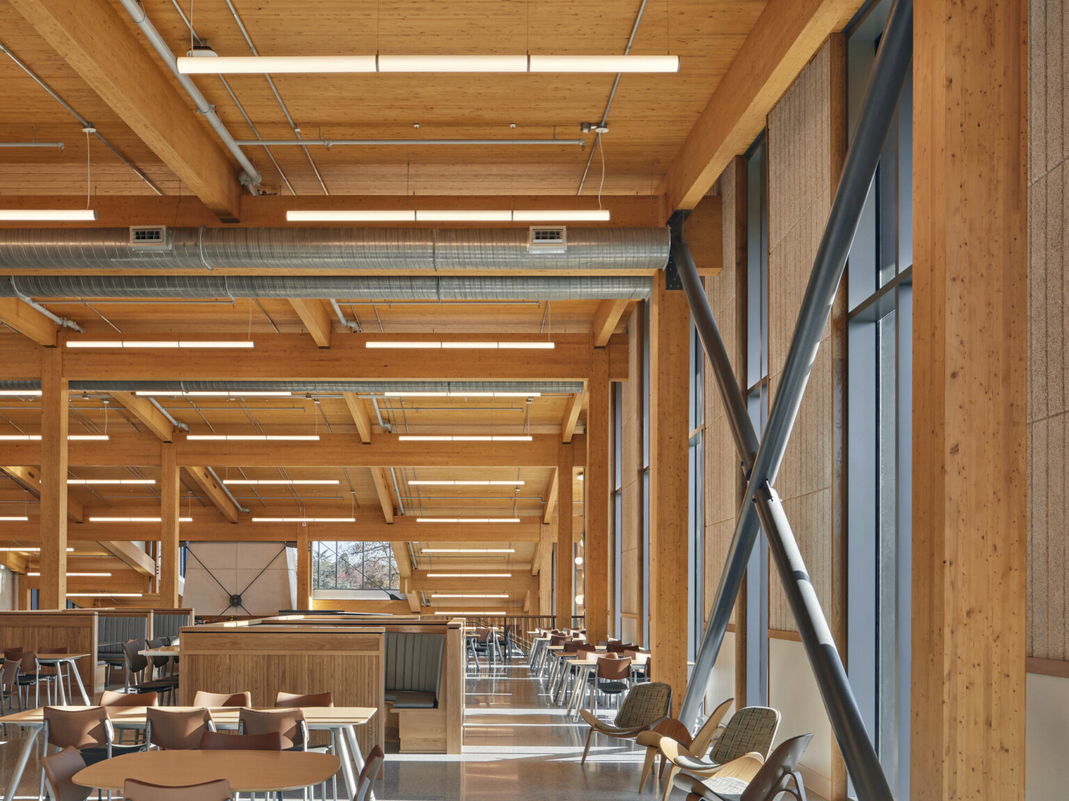 mass timber triple-height ceilings and stone walls, overhead energy-efficient low-wattage lighting, exposed ducting, steel supports, floor-to-ceiling windows provide natural light, wood and steel seating mass timber triple-height ceilings and stone walls, overhead energy-efficient low-wattage lighting, exposed ducting, steel supports, floor-to-ceiling windows provide natural light, wood and steel seating