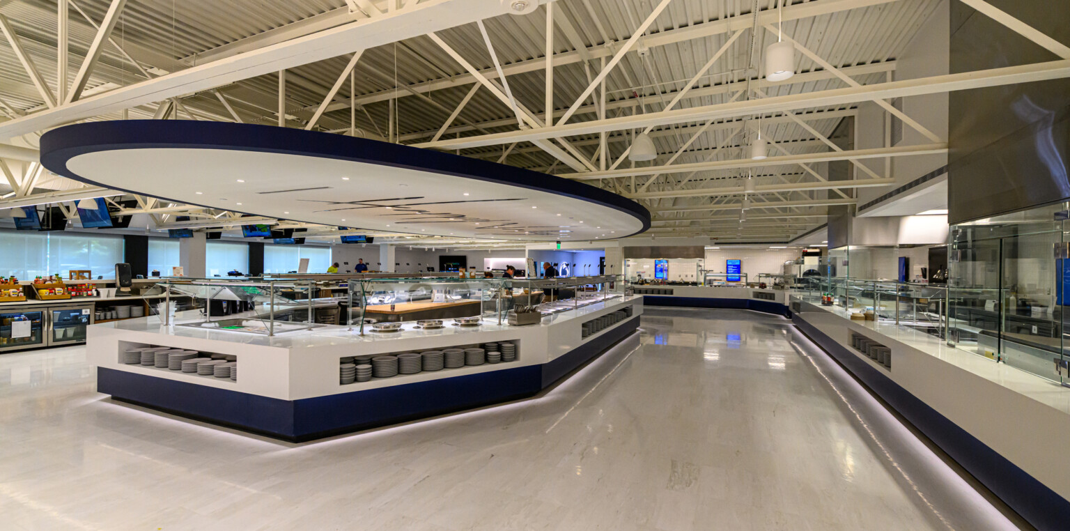 Penn State’s Greenberg Indoor Sports Complex dining space; large white buffet counter in the center of the room with similar counters on the perimeter of the space