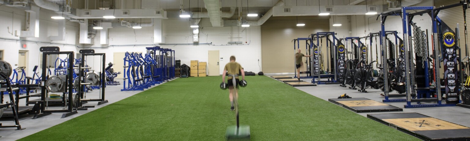 workout gym with turf and various exercise machines