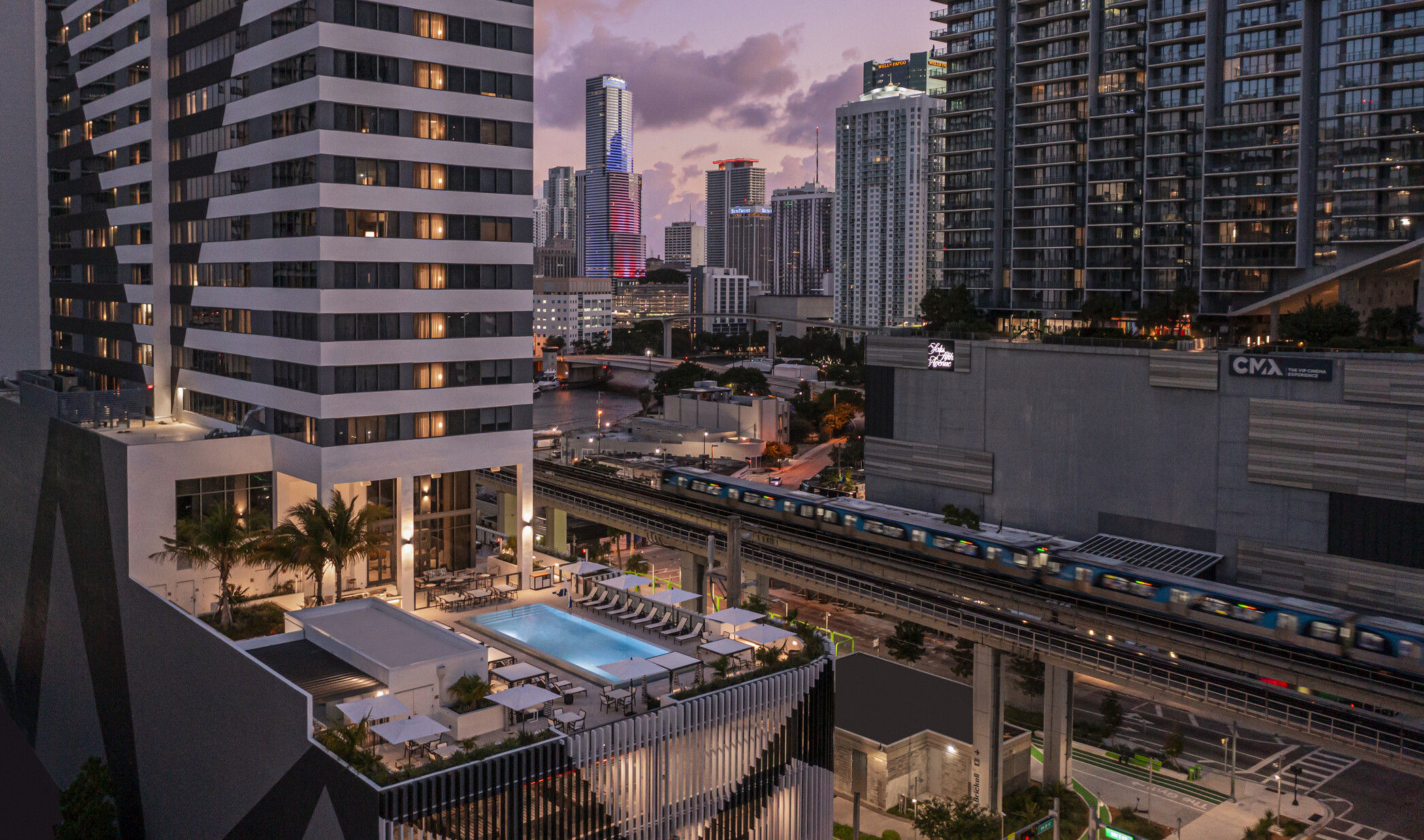 AC Hotel by Marriott and Element Miami Brickell, a tall tower with midlevel patio and outdoor pool with seating area in downtown Miami surrounded by tall buildings
