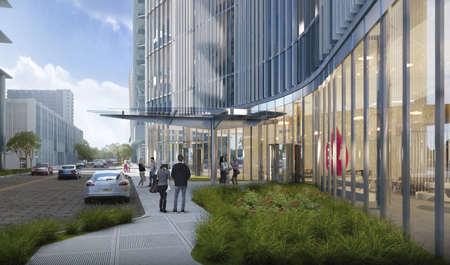 Building entry with glass shelter supported by metallic pillar and trusses leading to revolving door to lobby
