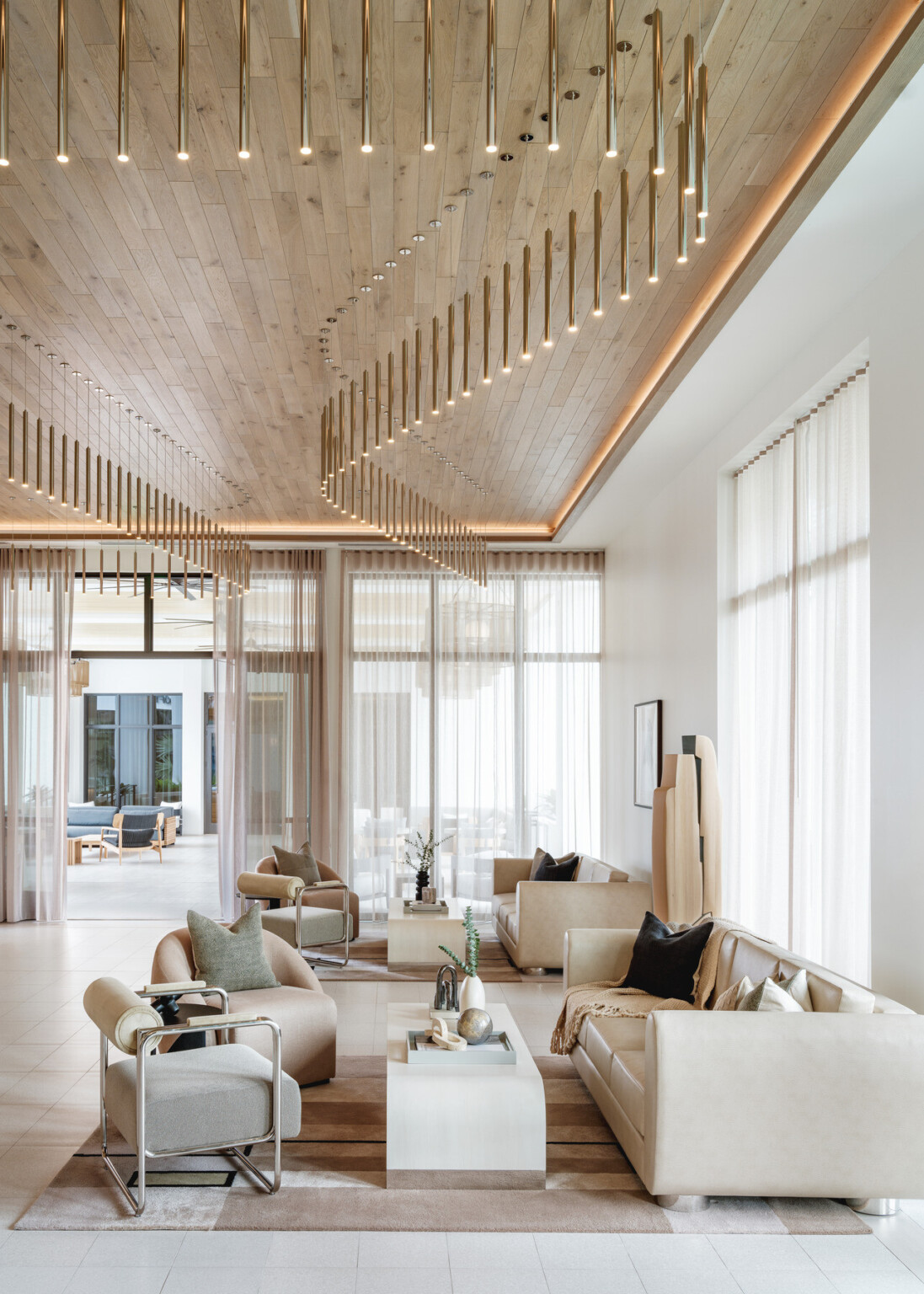 Modern hotel lobby with white couches on natural area rugs with natural wood ceilings and modern gold lighting