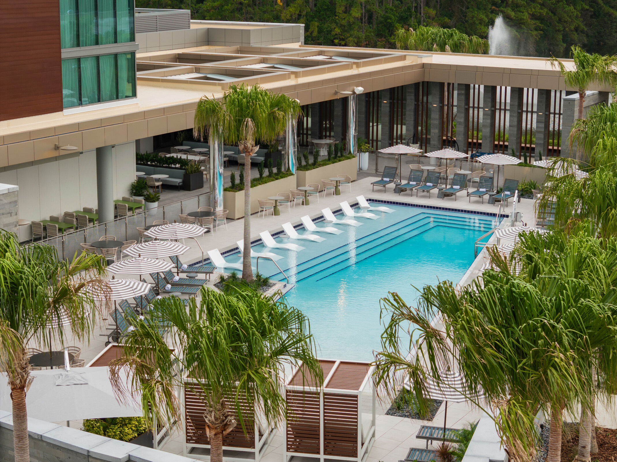 Resort-style pool at Hilton Jacksonville featuring private cabanas and architectural wall screening designed to enhance comfort and privacy