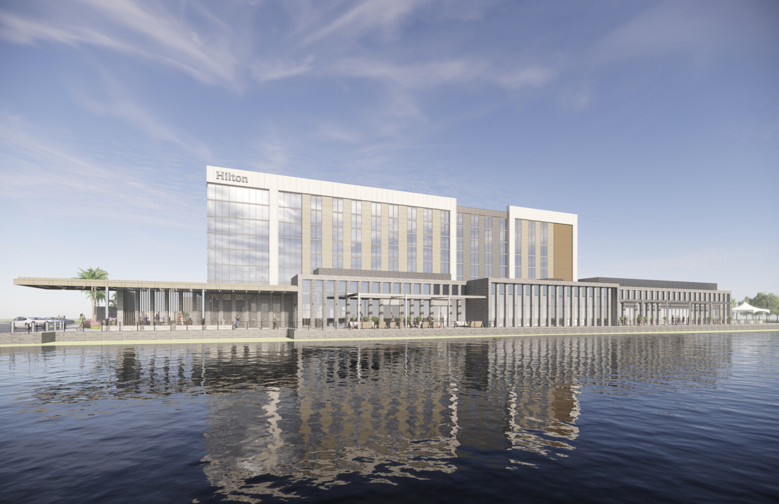 An eight-story hotel clad in wood battens, stone piers, and reflective paneling stands adjacent to a pond and flourishing landscape