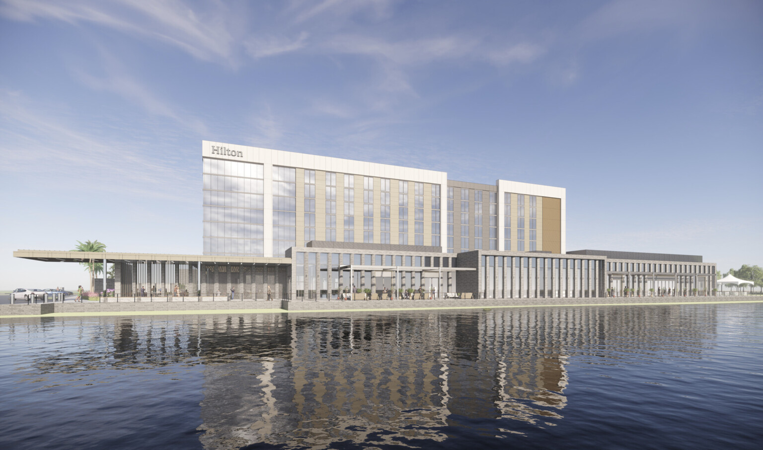 An eight-story hotel clad in wood battens, stone piers, and reflective paneling stands adjacent to a pond and flourishing landscape