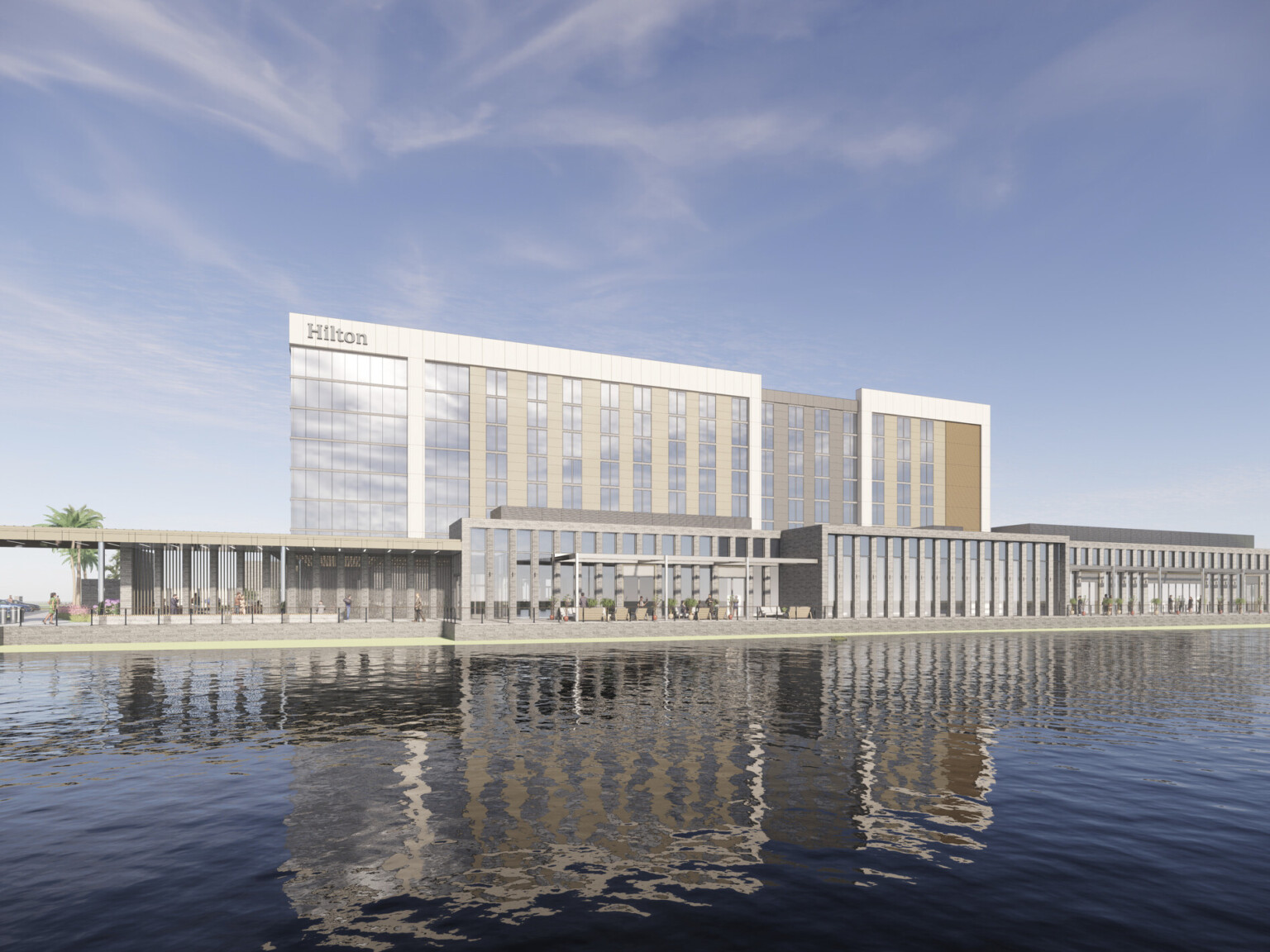 An eight-story hotel clad in wood battens, stone piers, and reflective paneling stands adjacent to a pond and flourishing landscape