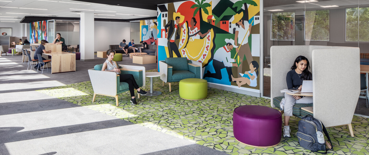 Students studying and engaging in conversation on couches at the Whitten University Center on the University of Miami campus.