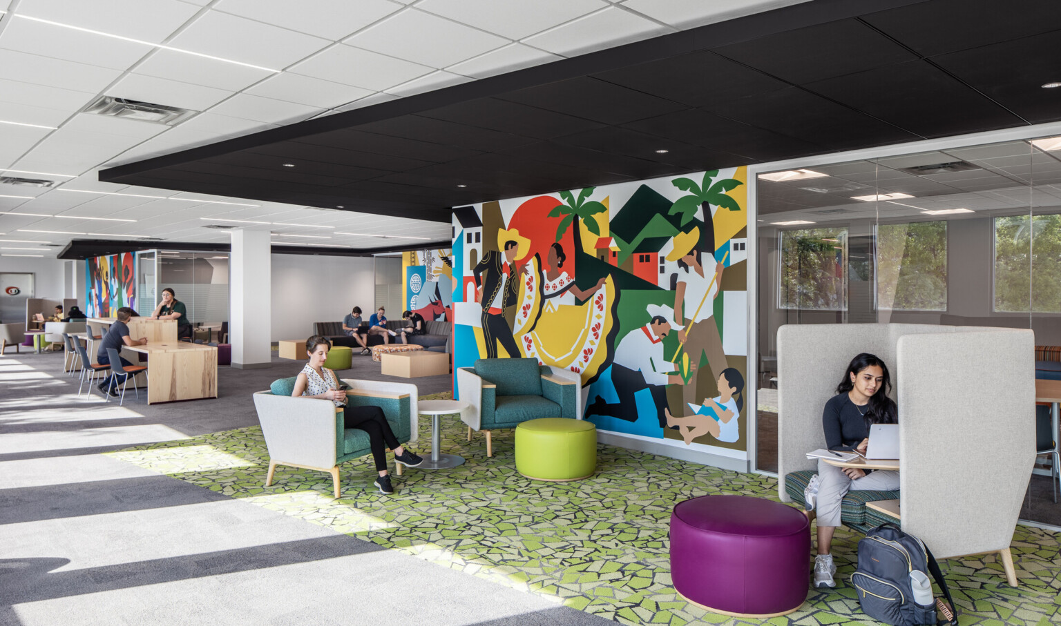 Students studying and engaging in conversation on couches at the Whitten University Center on the University of Miami campus.