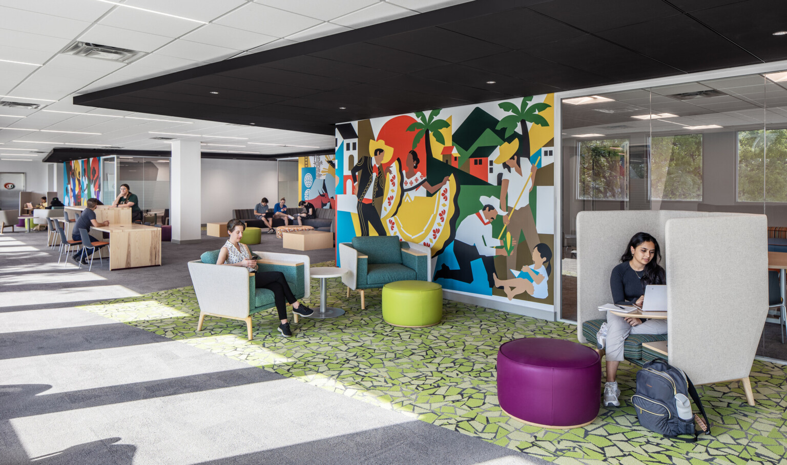 Students studying and engaging in conversation on couches at the Whitten University Center on the University of Miami campus.
