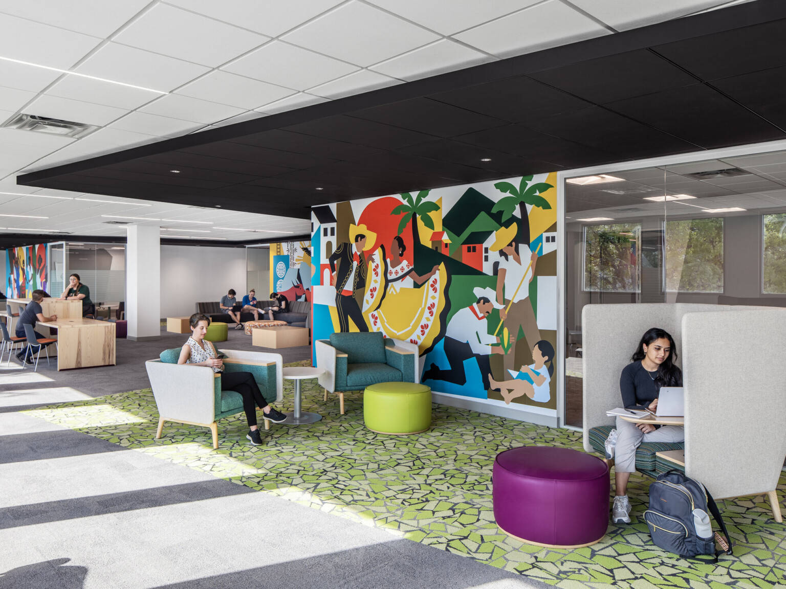 Students studying and engaging in conversation on couches at the Whitten University Center on the University of Miami campus.