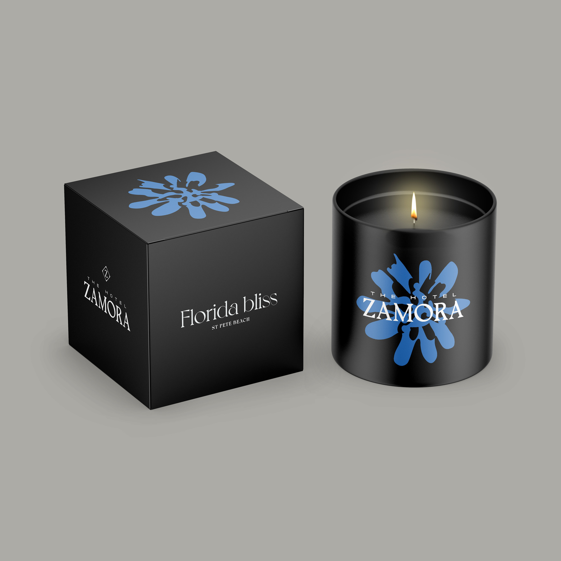 graphic design for hotel zamora; candle in front of a box with zamora branding and blue flower