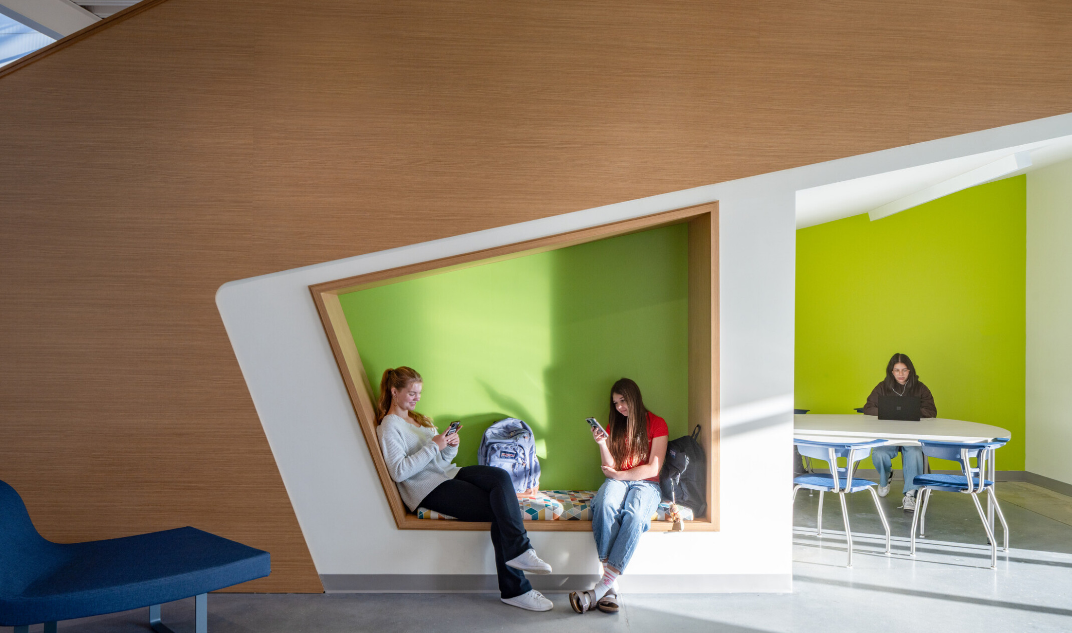 School hallway quiet nooks with built in bench and table seating; students sitting and independent studying