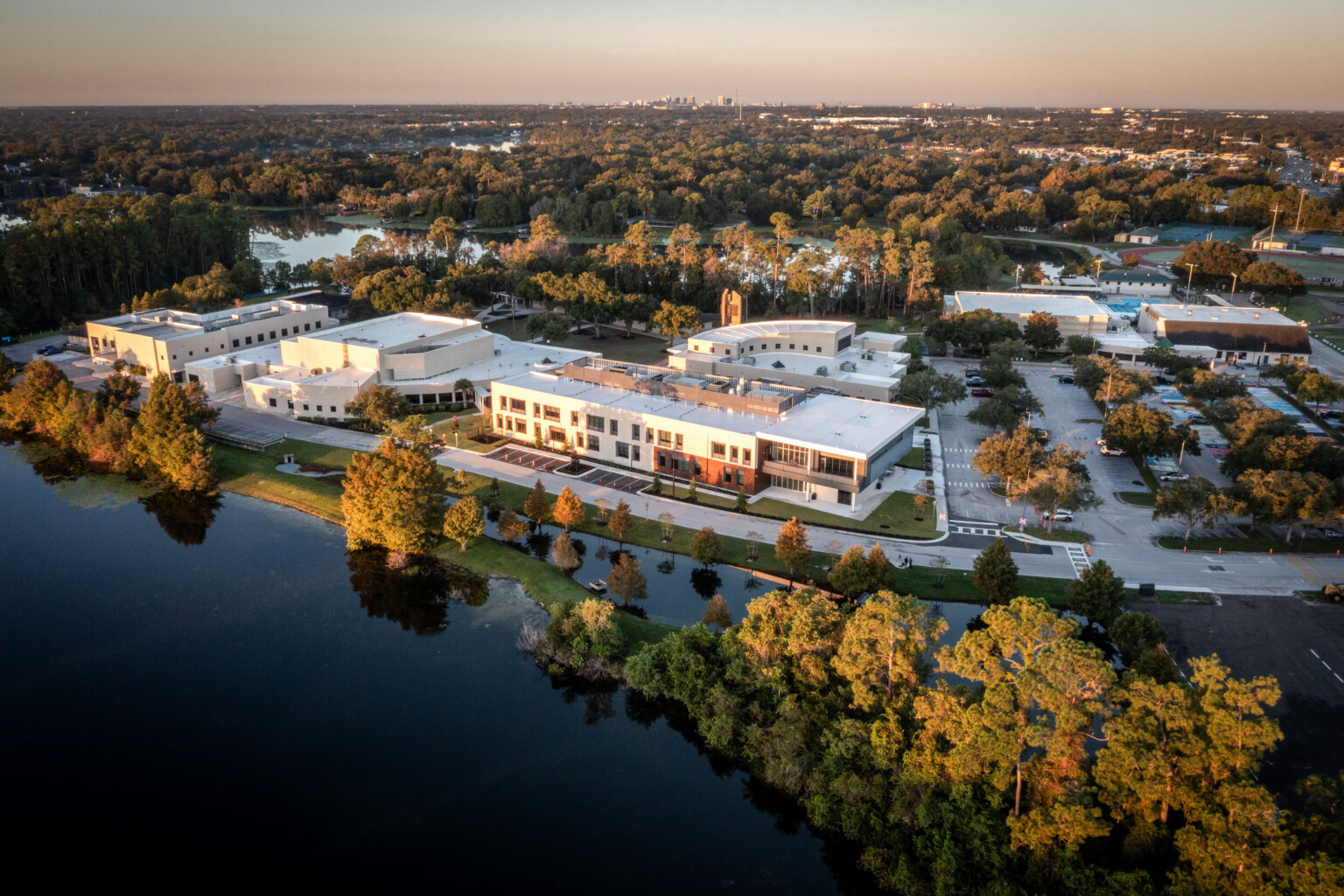 aerial image of a school campus aerial surrounded by fall colored trees and lake burkett