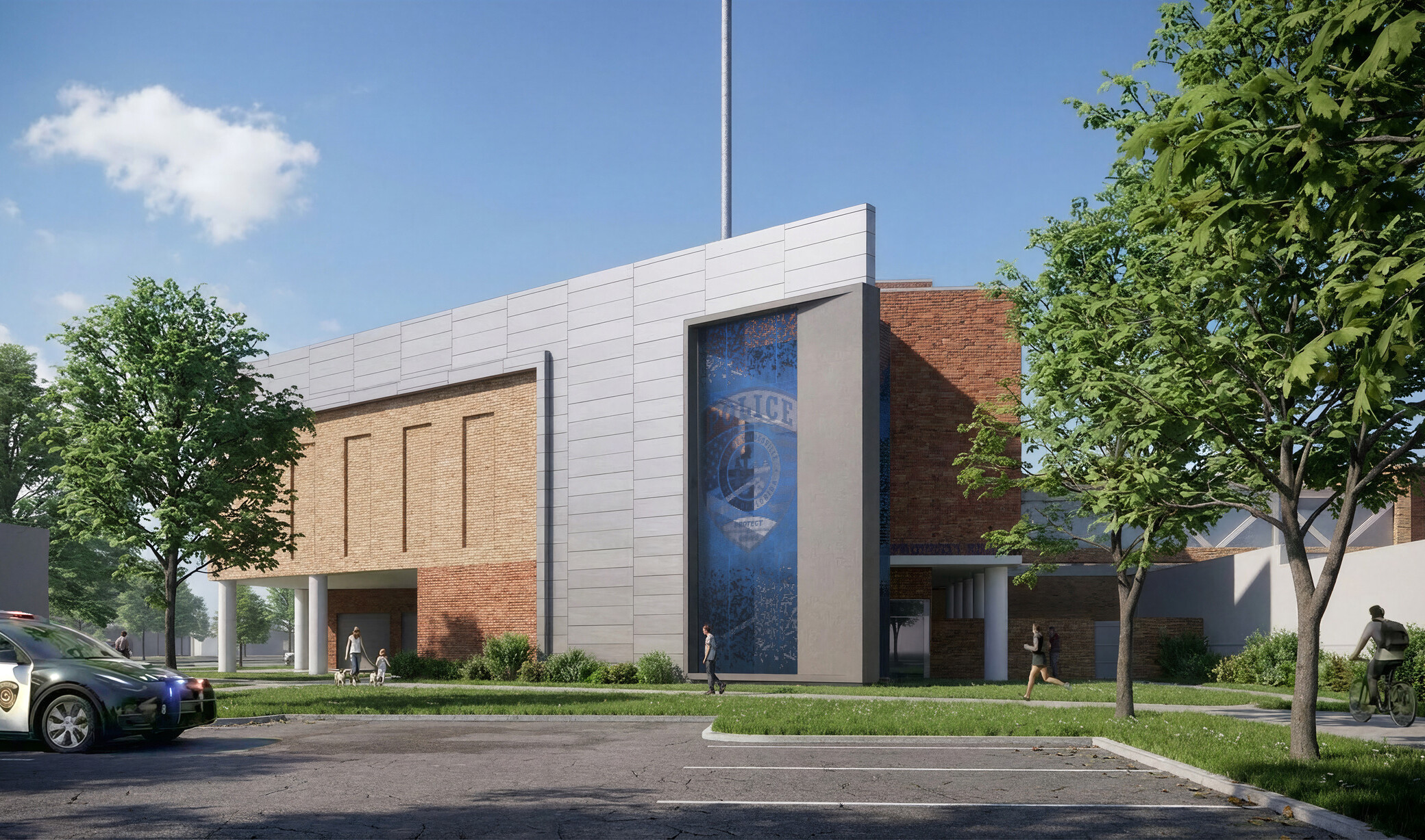 Exterior entry of the police property and entry building. Brick façade with metal panels and a large blue banner with a police badge in the center.